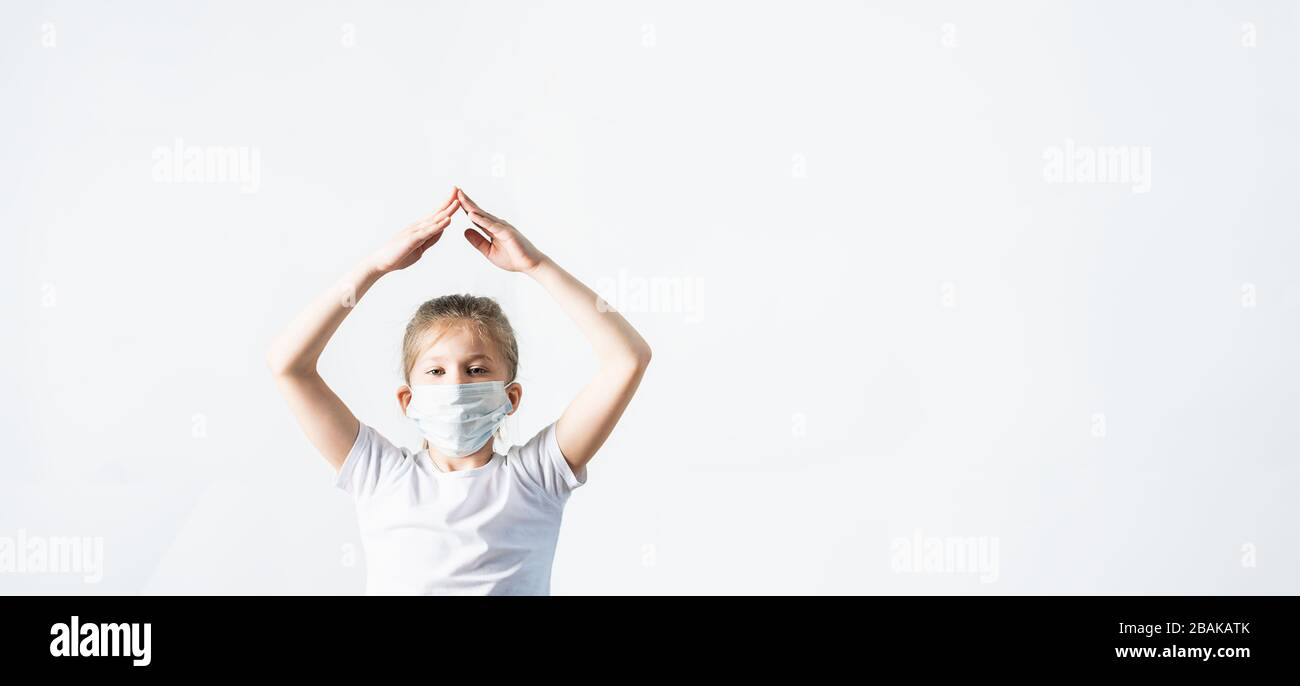 Das Mädchen in einer medizinischen Maske zeigt eine Geste des Schutzes vor Coronovirus-Erkrankungen. Das Konzept, die Epidemie Covid-19 zu stoppen. Horizontaler Fram Stockfoto