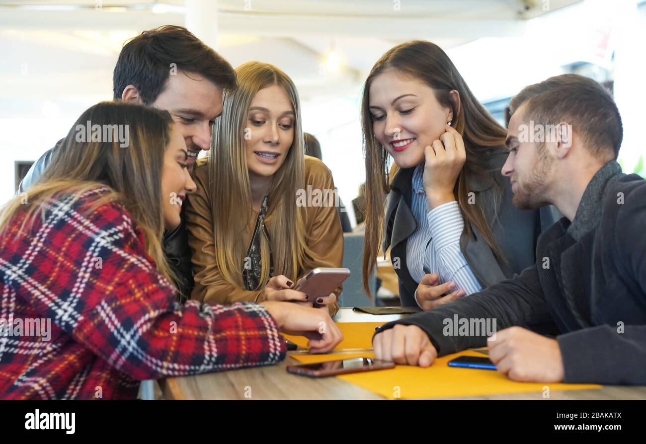 Eine Gruppe von Freunden, die mit ihren Mobiltelefonen in einer Bar sitzen - junge Leute, tausende von Festnetztelefonen, die Onli genießen Stockfoto
