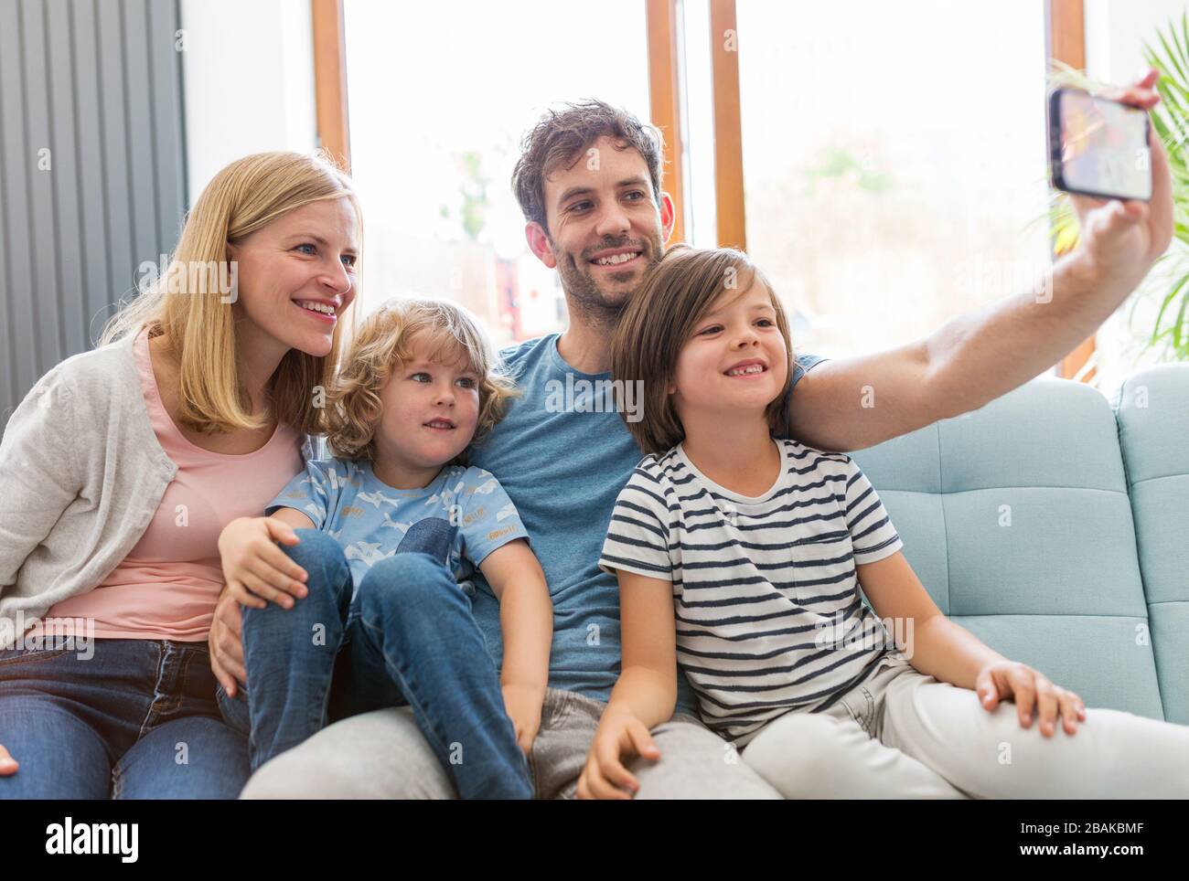 Glückliche junge Familie mit zwei Kindern zu Hause Stockfoto