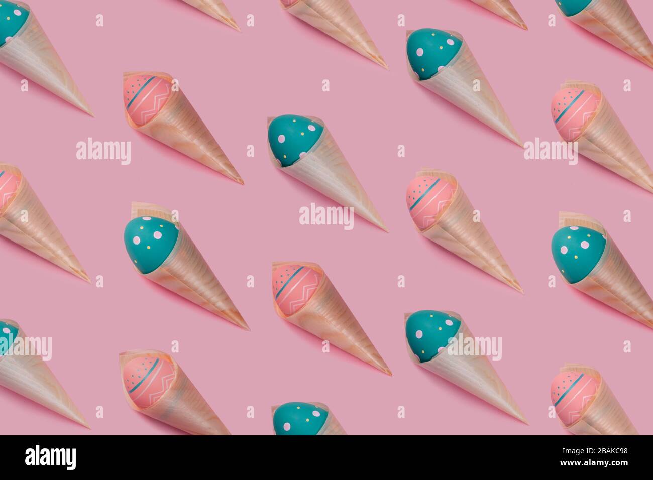 Muster mit farbig verzierten Eiern in Bambuskegeln sehen wie Eiscreme auf pinkfarbenem Hintergrund aus. Konzept von Ostern, Null Abfall, Ökologie, Kopierraum. Stockfoto