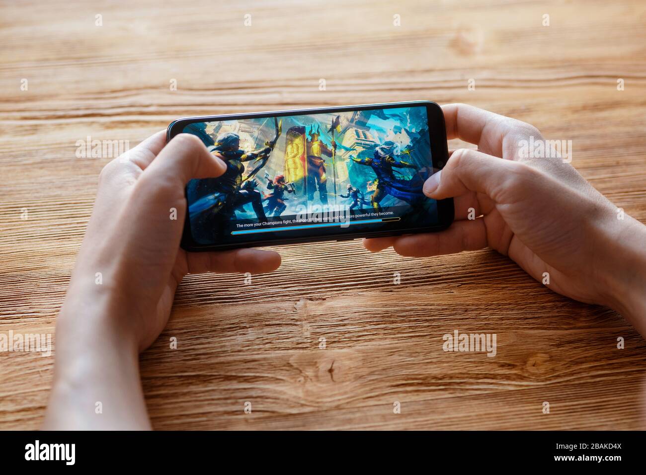Ein junger Kerl spielt auf dem Telefon das mobile Spiel 