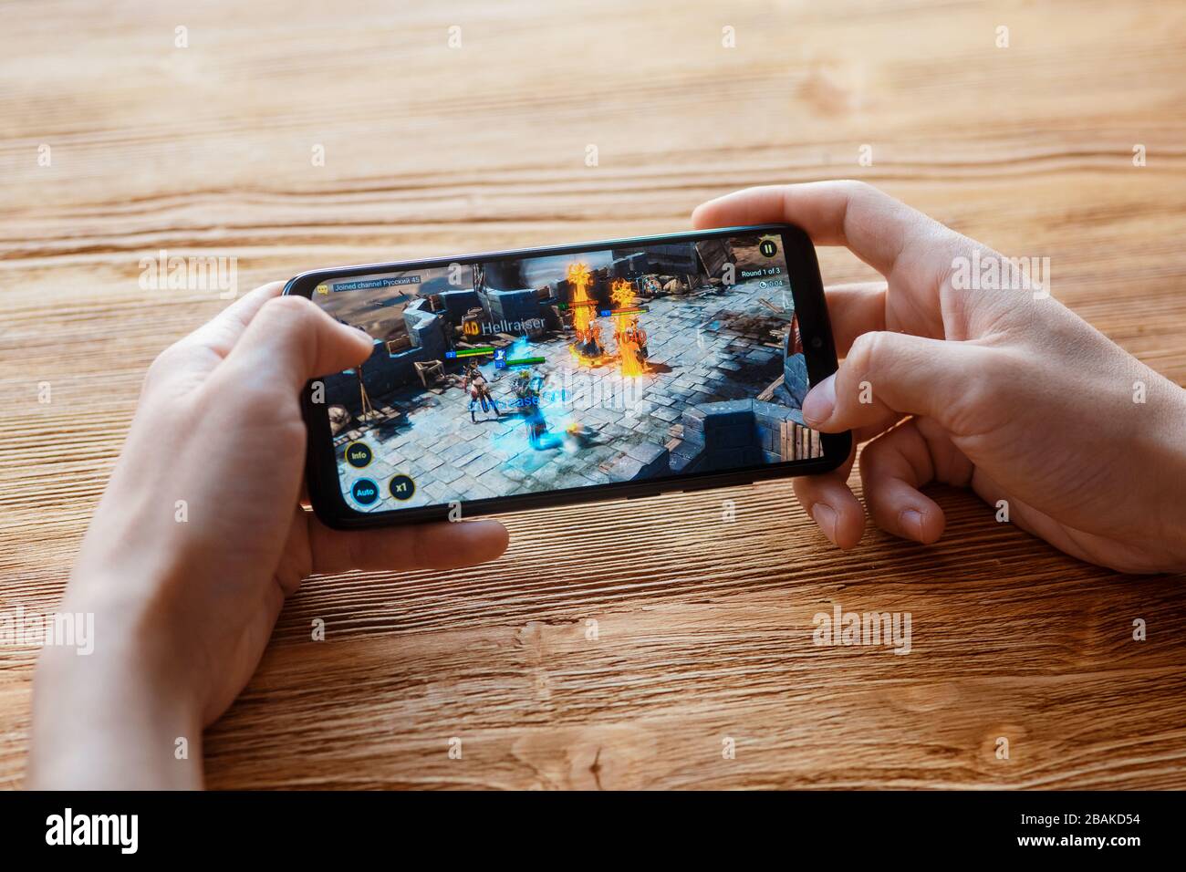 Ein junger Kerl spielt auf dem Telefon das mobile Spiel 