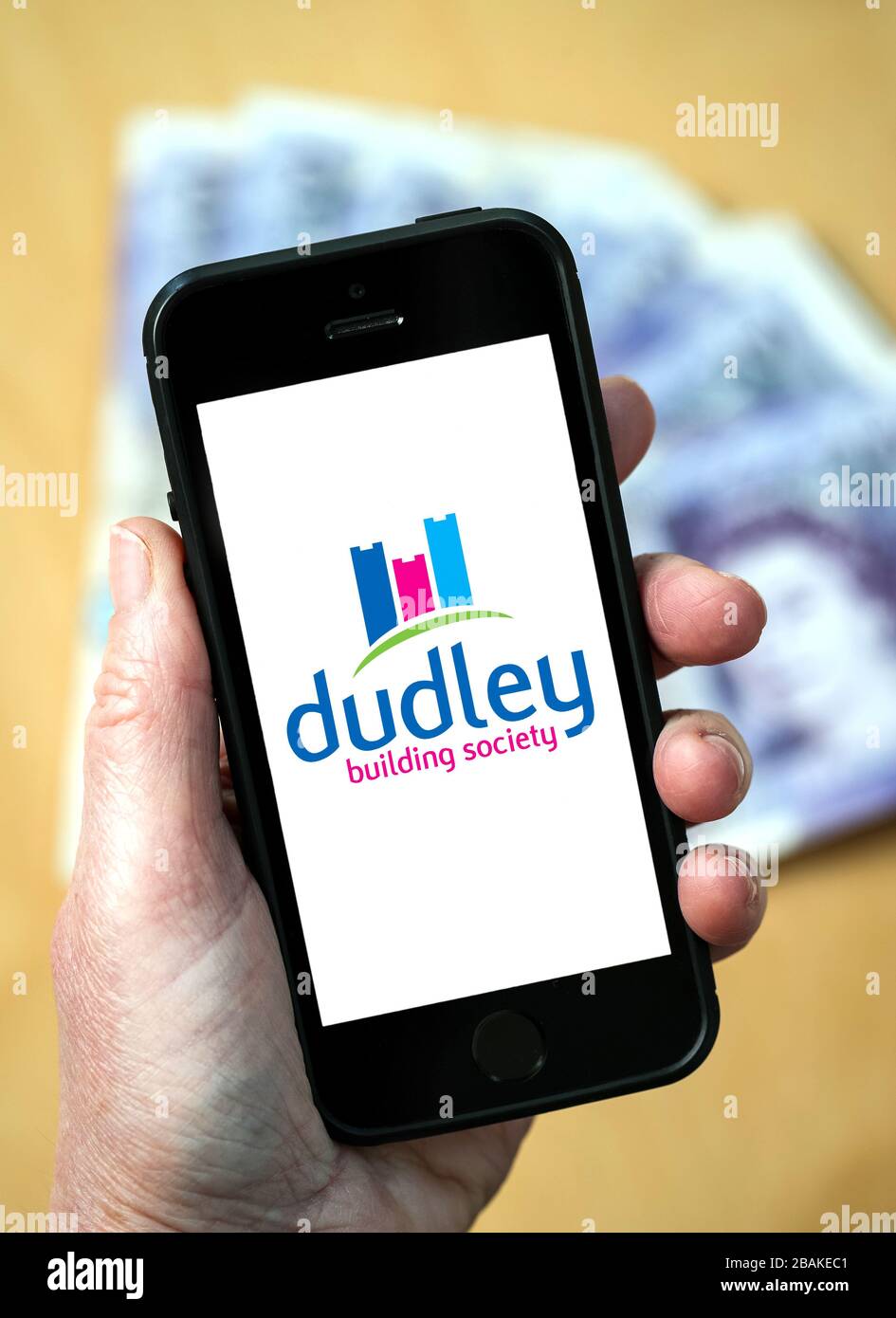 Eine Frau, die ein Mobiltelefon mit der Dudley Building Society hält (nur redaktionelle Verwendung) Stockfoto