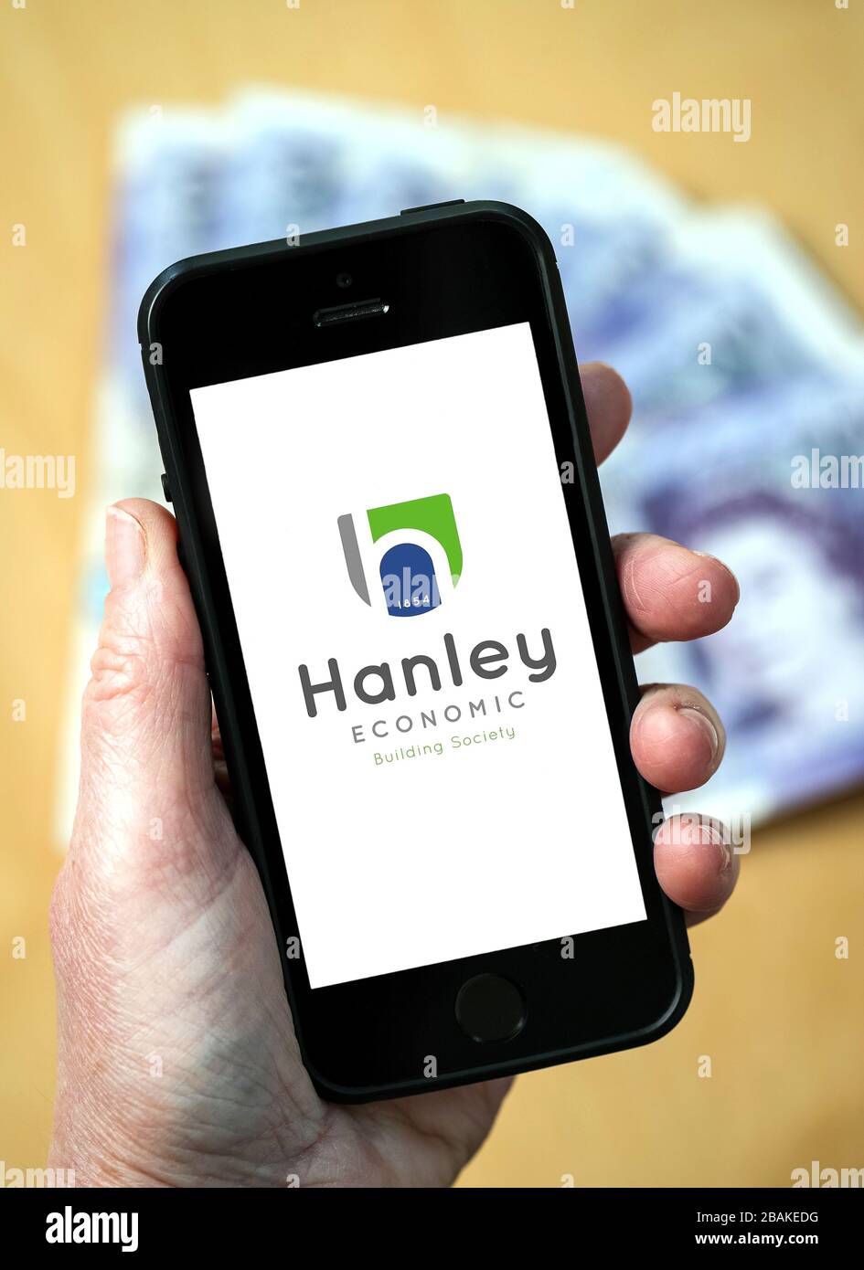 Eine Frau, die ein Mobiltelefon hält und Hanley Economic Building Society zeigt (nur redaktionelle Verwendung) Stockfoto
