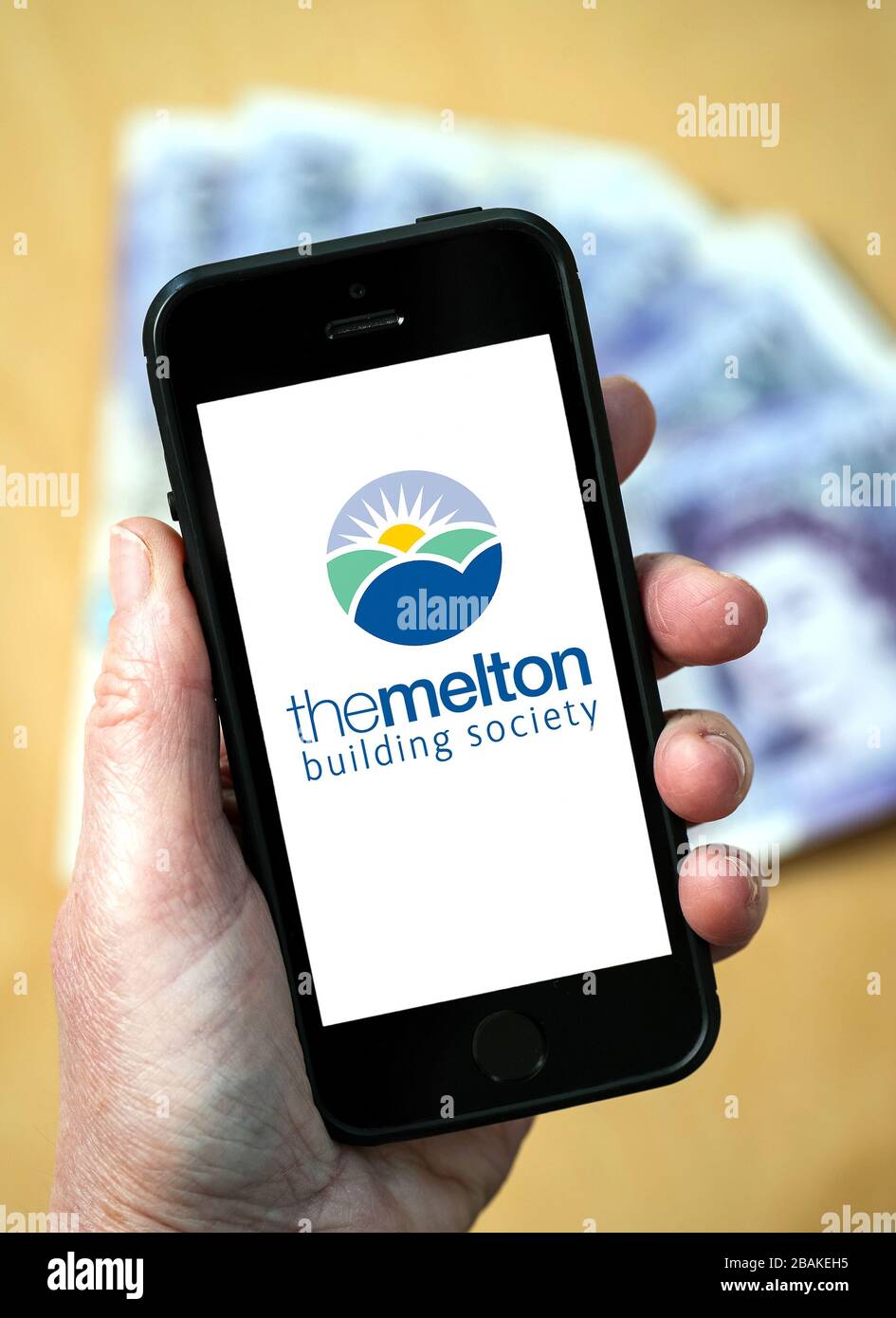 Eine Frau, die ein Mobiltelefon mit der Melton Building Society hält (nur redaktionelle Verwendung) Stockfoto