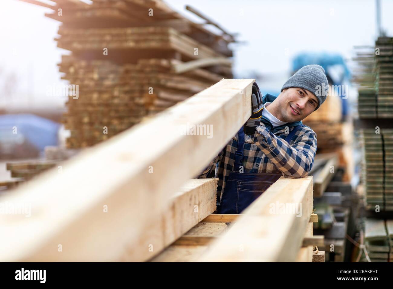 Junger männlicher Arbeiter im Holzlager Stockfoto