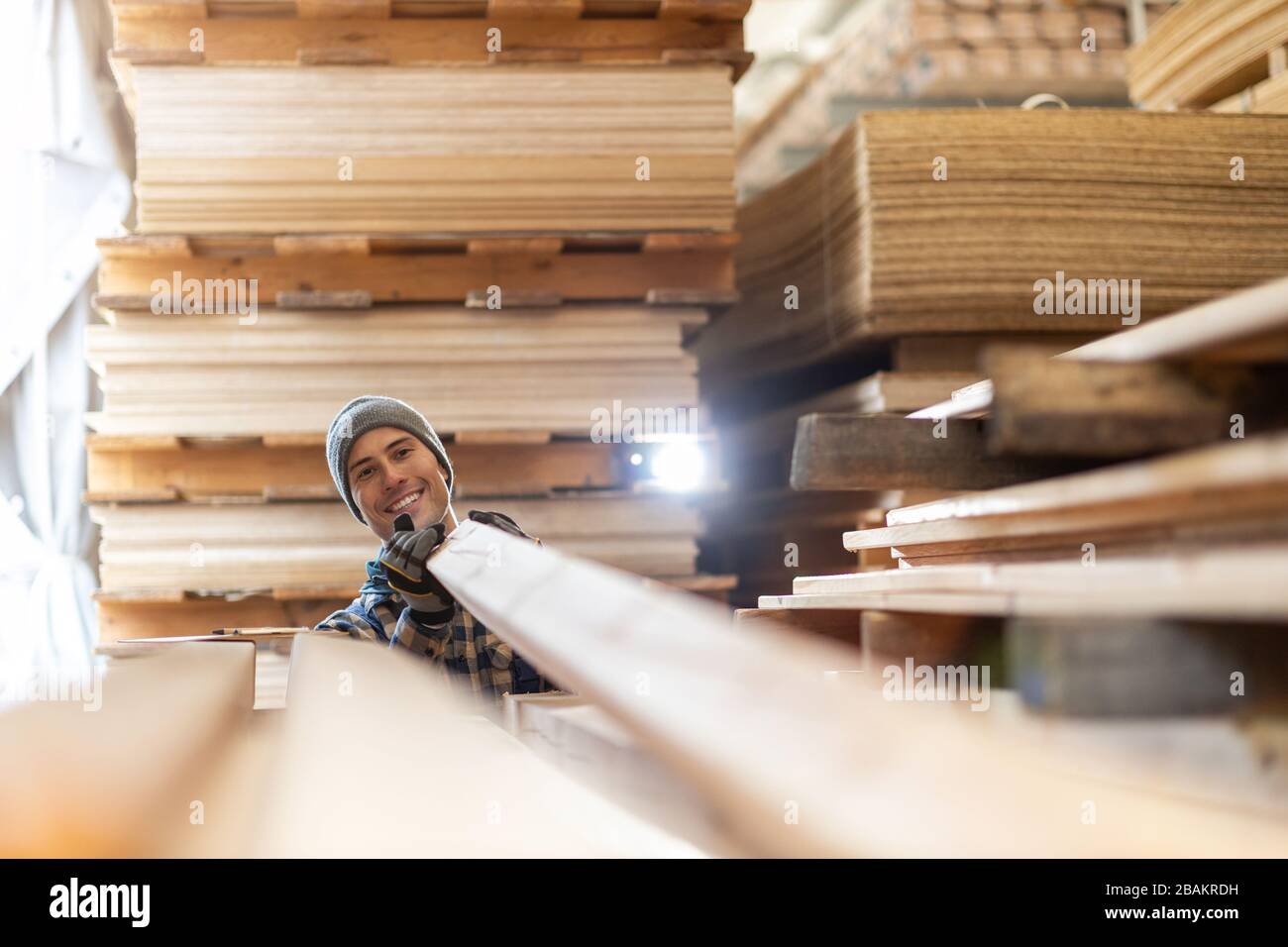 Junger männlicher Arbeiter im Holzlager Stockfoto