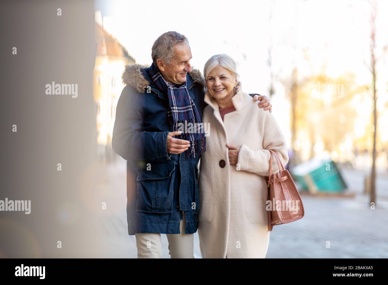 Älteres Paar, das am Wintertag auf der Straße der Stadt spazieren geht Stockfoto