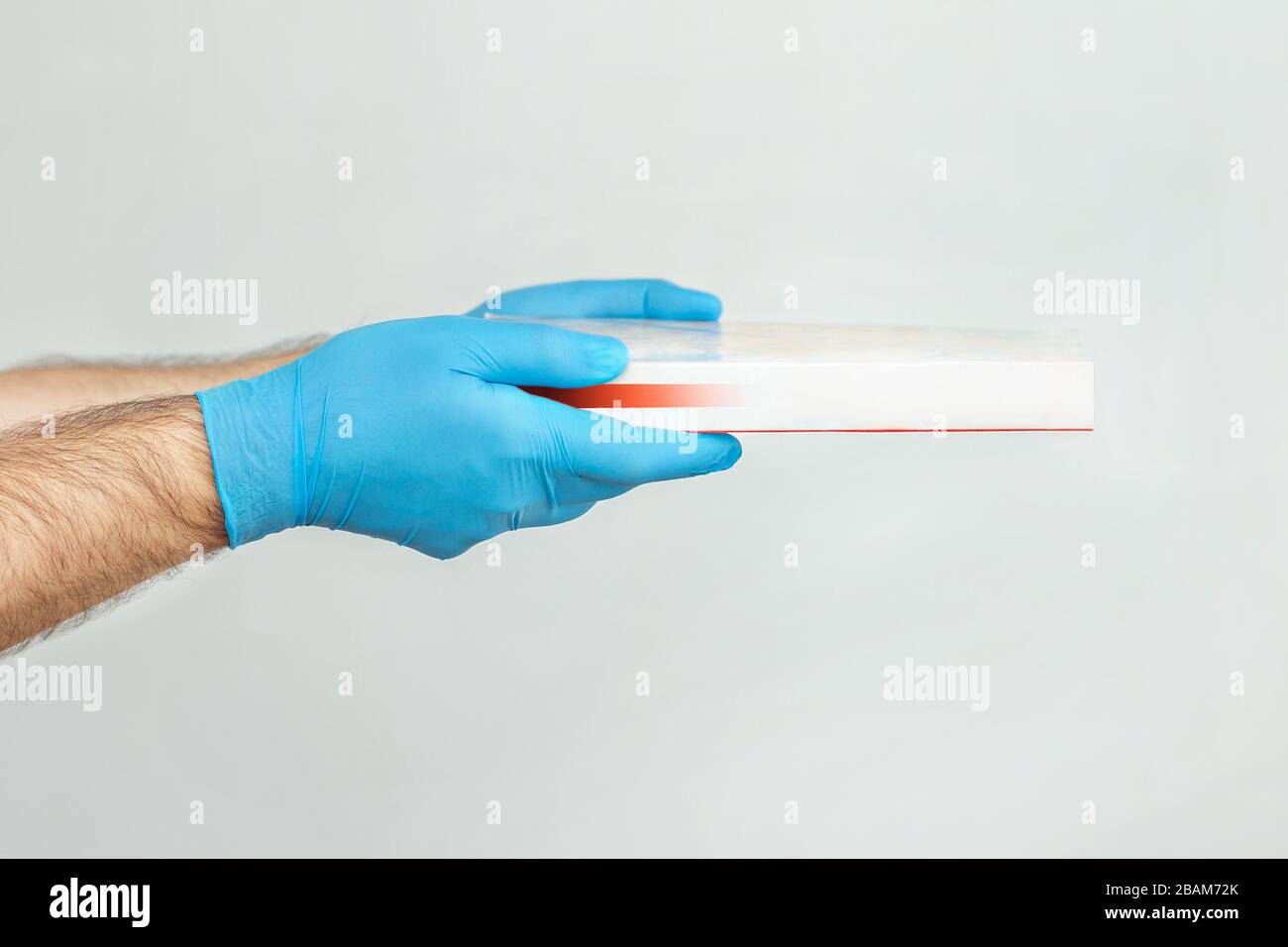 Pizza Lieferung. Lieferer, der Kartons hält.Zustellung per Kurier in medizinischen Gummihandschuhen. Stockfoto