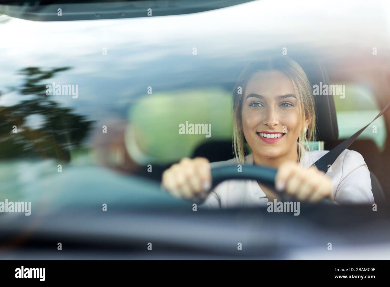 Junge Frau mit verbundenen Augen am Steuer eines Autos foto de