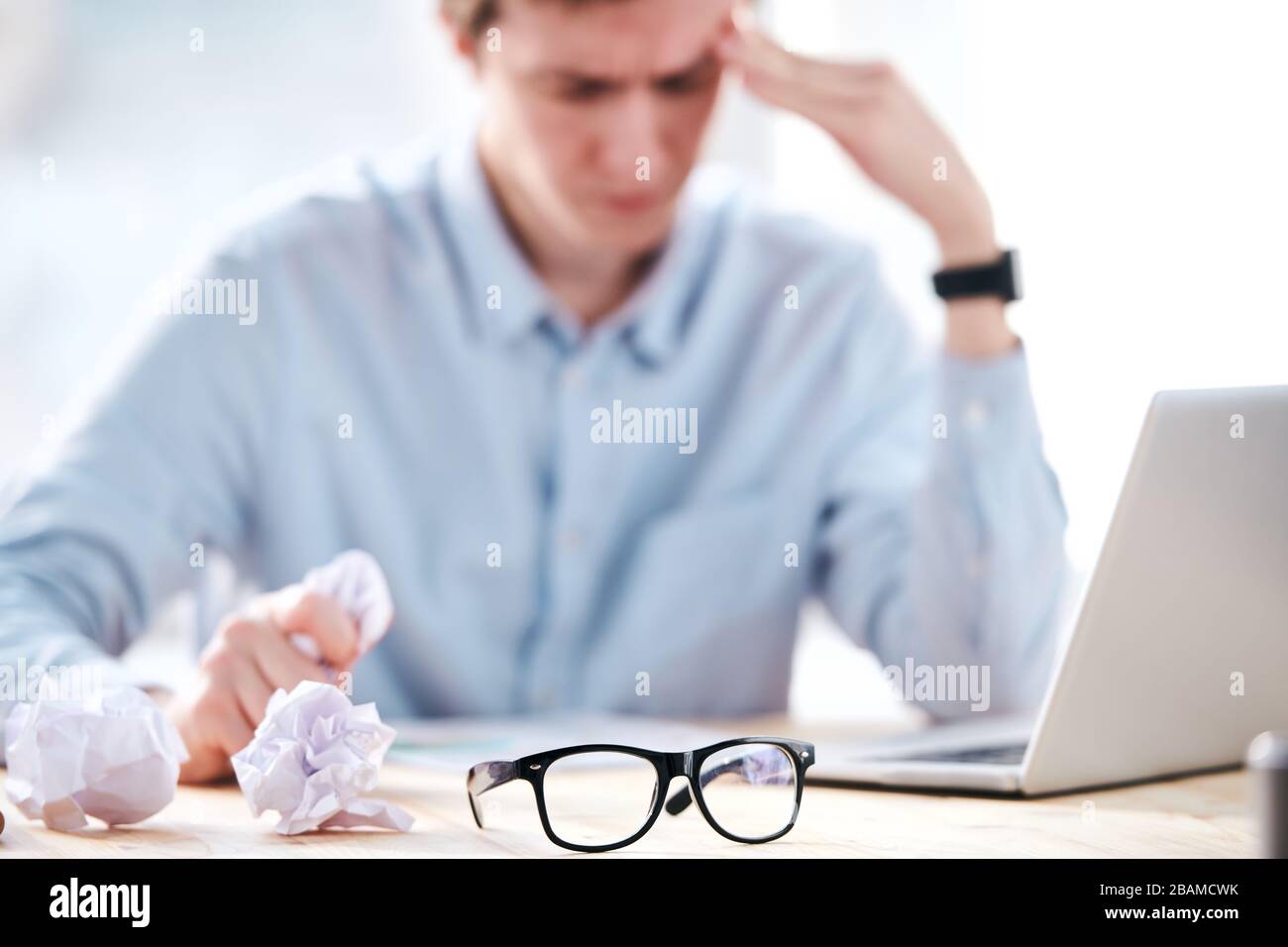 Nahaufnahme der jungen Unternehmer zerfallen die Papiere, ohne Ideen für ein Projekt im Büro zu haben, konzentrieren sich auf Brillen im Vordergrund Stockfoto
