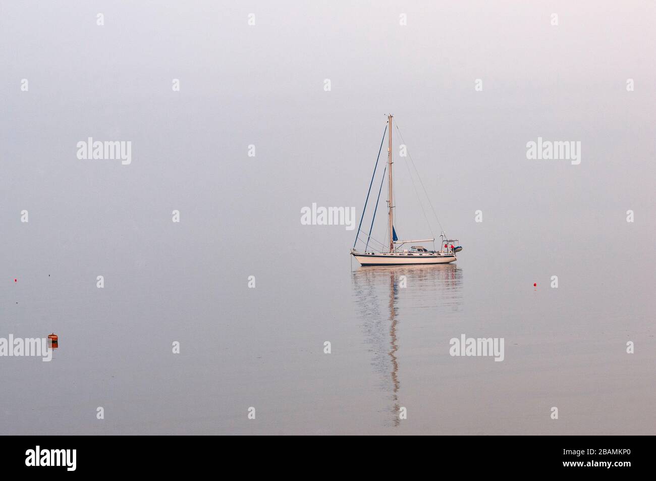 segelboot an einem nebligen Abend, Moelfre, Anglesey, Wales Stockfoto