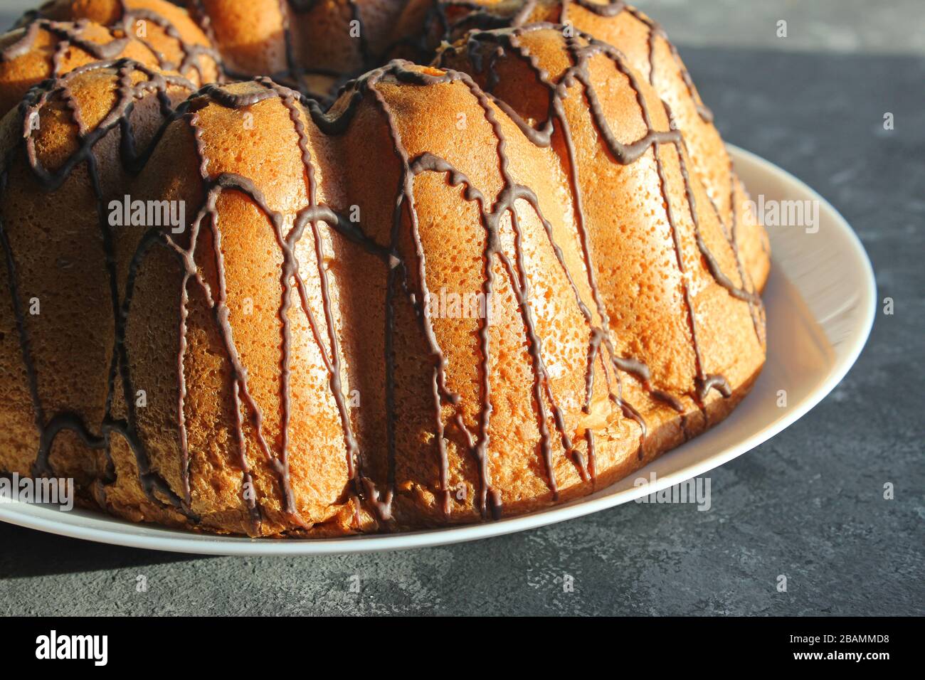 Ein selbstgebackener Kuchen wird von der Sonne angezündet. Am frühen Morgen. Frühstück. Hausgemachtes Backen mit Schokolade Stockfoto