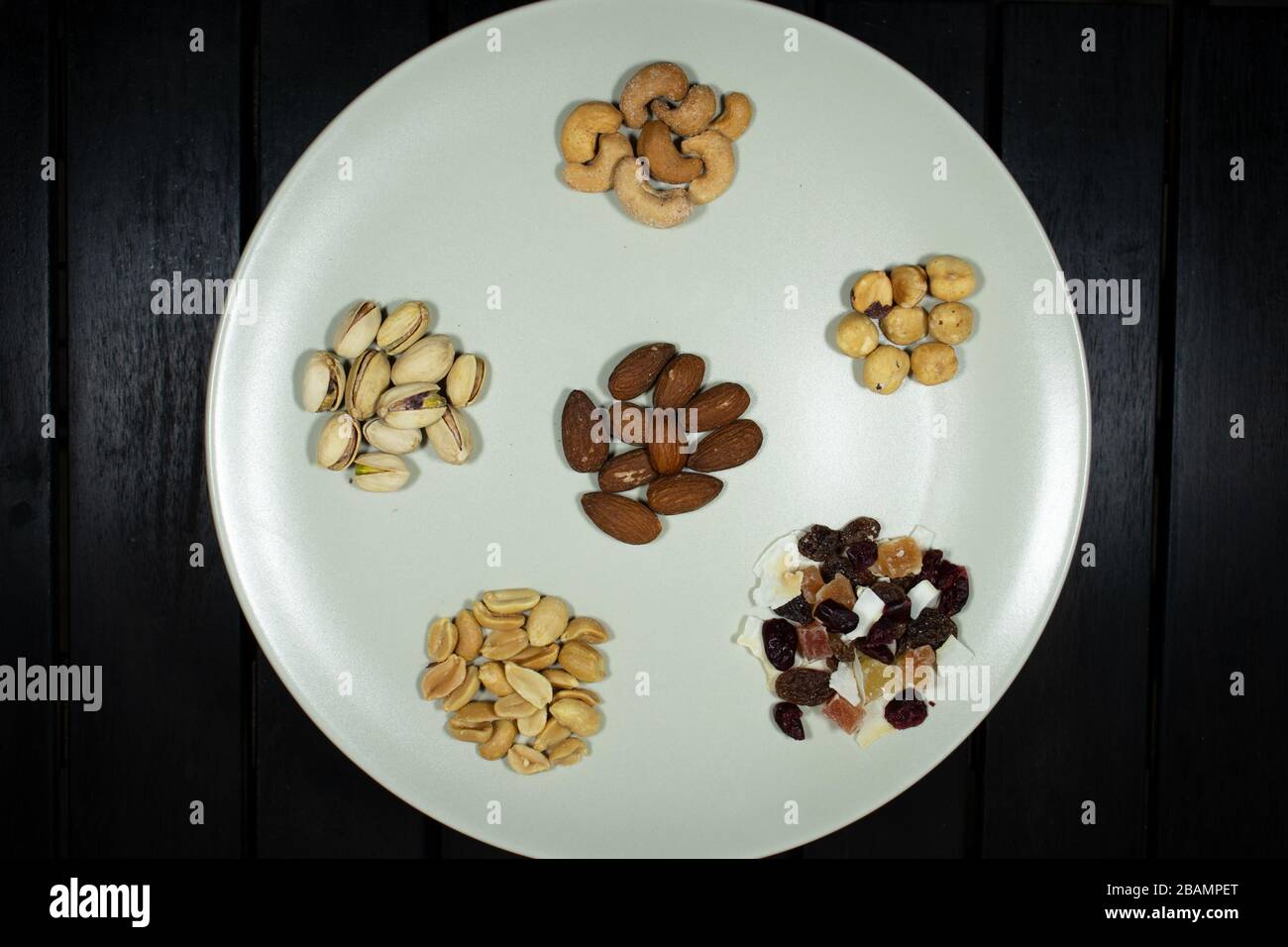 Verschiedene Arten von Nüssen in Weißgericht Mandeln in Draufsicht, Pistachios, Cashews, Erdnuss, Haselnuss, Trockenfrüchte Stockfoto