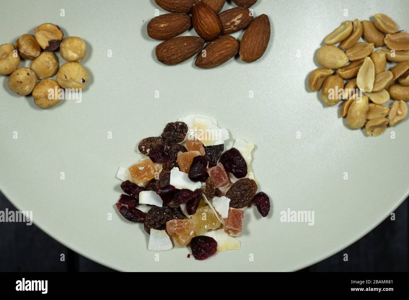 Verschiedene Arten von Nüssen in Weißgericht Mandeln in Draufsicht, Pistachios, Cashews, Erdnuss, Haselnuss, Trockenfrüchte Stockfoto