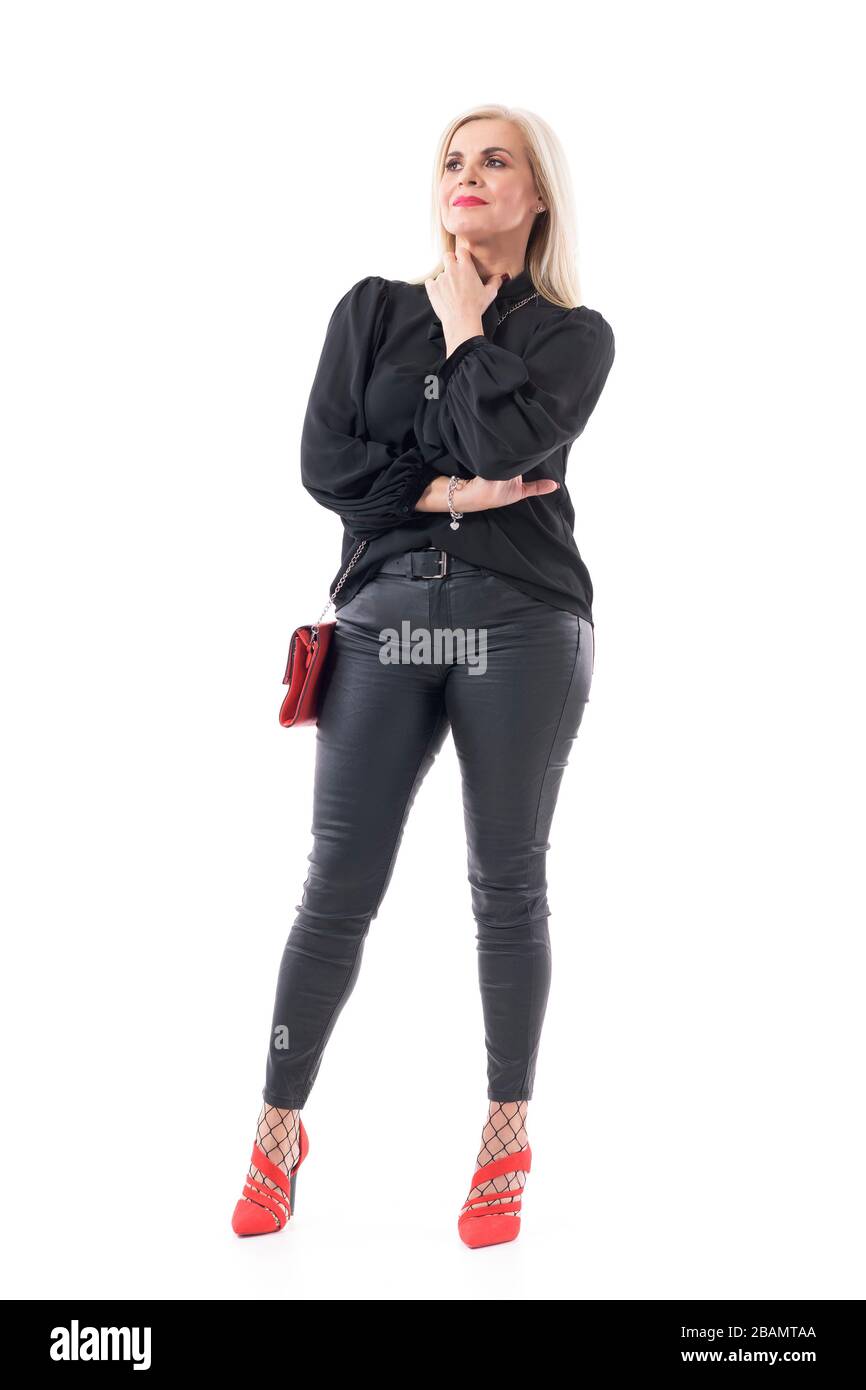 Hübsche elegante, elegante Frau mittleren Alters, die denkt und bedenkt, dass sie einen berührenden Hals wegschaut. Volle Körperlänge auf weißem Hintergrund isoliert. Stockfoto