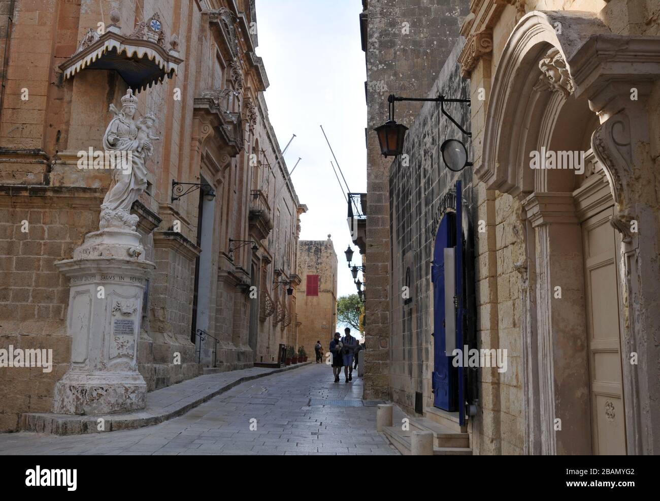 Die Menschen gehen entlang einer Straße in der historischen ummauerten Stadt Mdina, Malta. Bekannt als die Stille Stadt, ist Mdina ein beliebtes Ziel für Touristen. Stockfoto