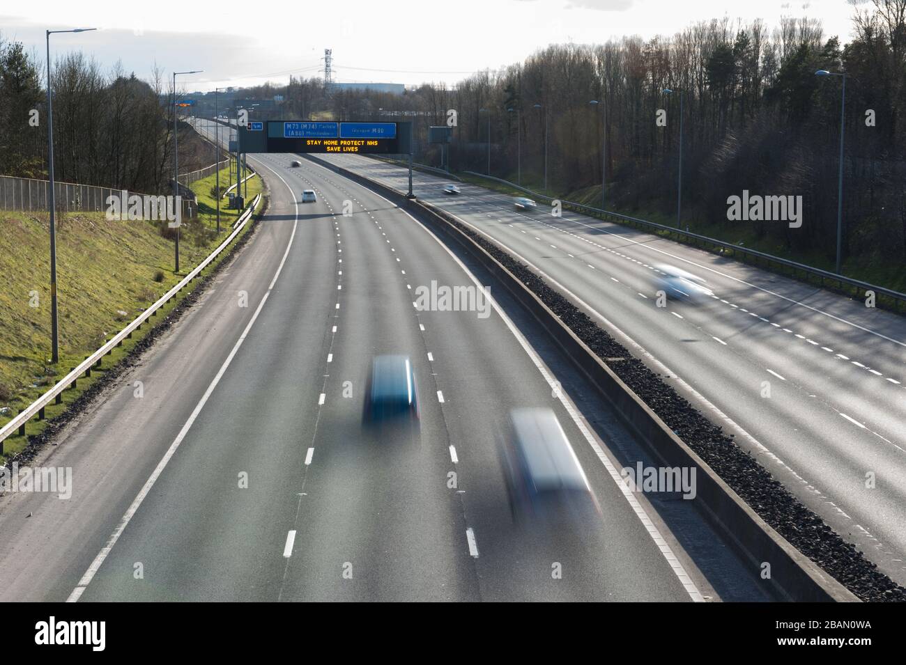 Glasgow, Großbritannien. März 2020. Abgebildet: Straßenschilder auf den Autobahnen M8 und M80, die lauten: "BLEIBEN SIE ZU HAUSE SCHÜTZEN Sie NHS RETTEN SIE LEBEN" die Pandemie von Coronavirus hat die britische Regierung gezwungen, eine Abschaltung aller britischen Großstädte anzuordnen und die Menschen zu Hause zu lassen. Das hat die Autobahnen und alle anderen Straßen frei von der üblichen Nase gelassen, um den Verkehr, der sonst da wäre, zu vereitelen. Kredit: Colin Fisher/Alamy Live News Stockfoto