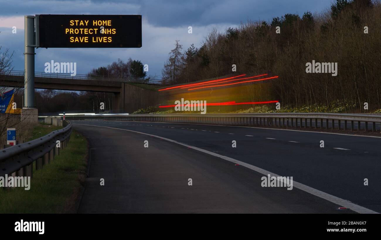 Glasgow, Großbritannien. März 2020. Abgebildet: Straßenschilder auf den Autobahnen M8 und M80, die lauten: "BLEIBEN SIE ZU HAUSE SCHÜTZEN Sie NHS RETTEN SIE LEBEN" die Pandemie von Coronavirus hat die britische Regierung gezwungen, eine Abschaltung aller britischen Großstädte anzuordnen und die Menschen zu Hause zu lassen. Das hat die Autobahnen und alle anderen Straßen frei von der üblichen Nase gelassen, um den Verkehr, der sonst da wäre, zu vereitelen. Kredit: Colin Fisher/Alamy Live News Stockfoto