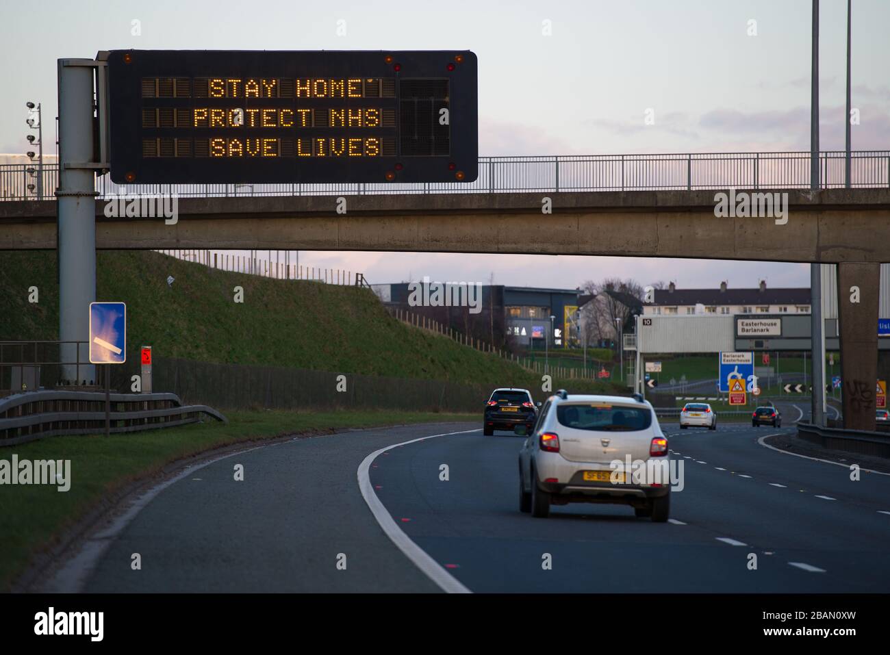 Glasgow, Großbritannien. März 2020. Abgebildet: Straßenschilder auf den Autobahnen M8 und M80, die lauten: "BLEIBEN SIE ZU HAUSE SCHÜTZEN Sie NHS RETTEN SIE LEBEN" die Pandemie von Coronavirus hat die britische Regierung gezwungen, eine Abschaltung aller britischen Großstädte anzuordnen und die Menschen zu Hause zu lassen. Das hat die Autobahnen und alle anderen Straßen frei von der üblichen Nase gelassen, um den Verkehr, der sonst da wäre, zu vereitelen. Kredit: Colin Fisher/Alamy Live News Stockfoto