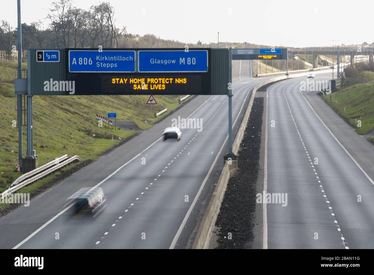 Glasgow, Großbritannien. März 2020. Abgebildet: Straßenschilder auf den Autobahnen M8 und M80, die lauten: "BLEIBEN SIE ZU HAUSE SCHÜTZEN Sie NHS RETTEN SIE LEBEN" die Pandemie von Coronavirus hat die britische Regierung gezwungen, eine Abschaltung aller britischen Großstädte anzuordnen und die Menschen zu Hause zu lassen. Das hat die Autobahnen und alle anderen Straßen frei von der üblichen Nase gelassen, um den Verkehr, der sonst da wäre, zu vereitelen. Kredit: Colin Fisher/Alamy Live News Stockfoto