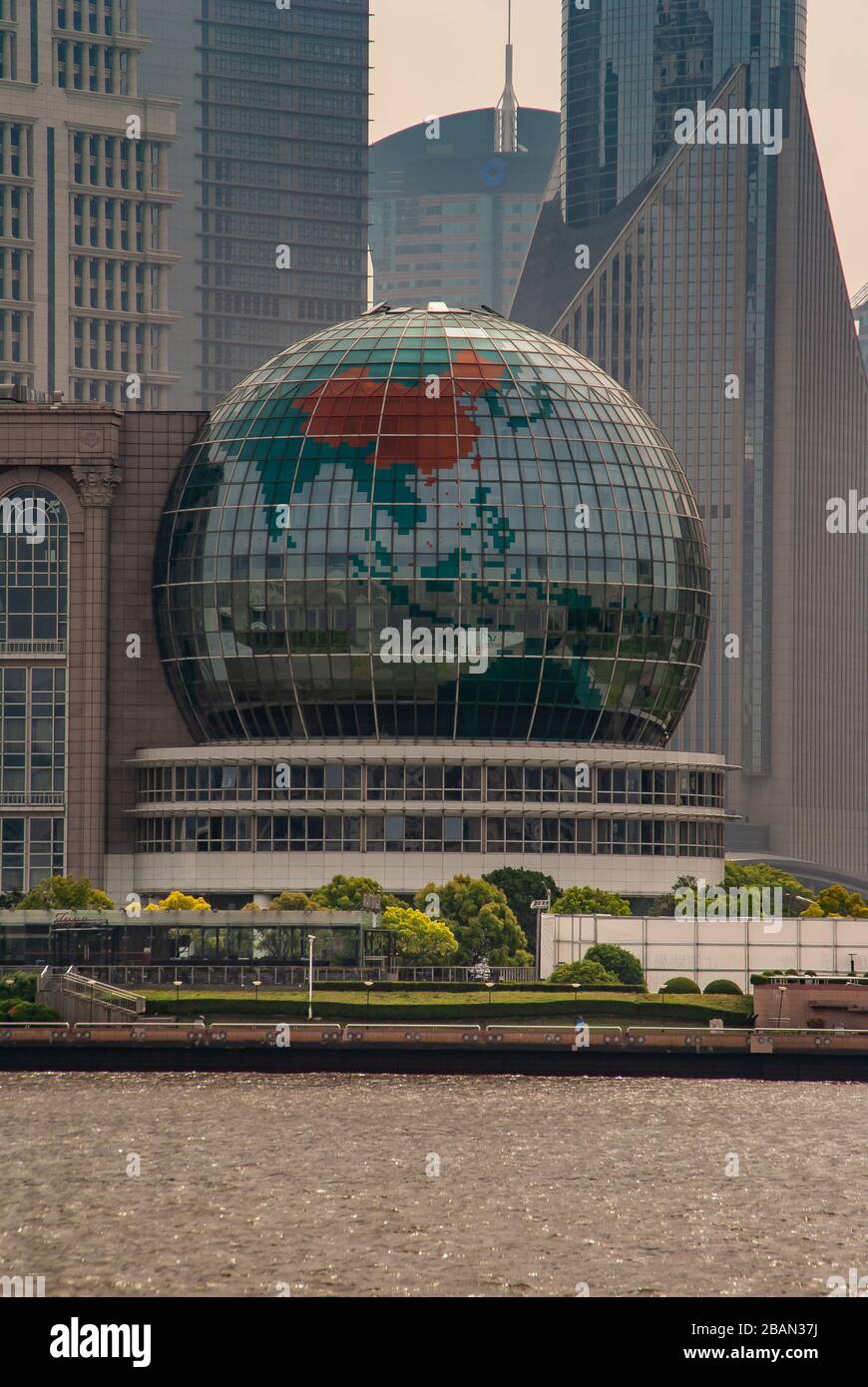 Shanghai, Pudong, Lujiazui, China - 4. Mai 2010: Gigantischer Glaskugel auf der Seite des Internationalen Konferenzzentrums. Teile der Wolkenkratzer im Rücken. B. Stockfoto