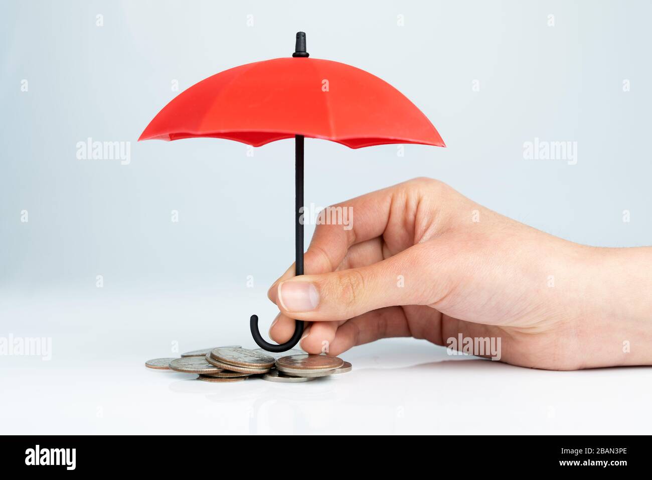 Schutz der Münzen mit Regenschirm für das Konzept der finanziellen Sicherheit Stockfoto