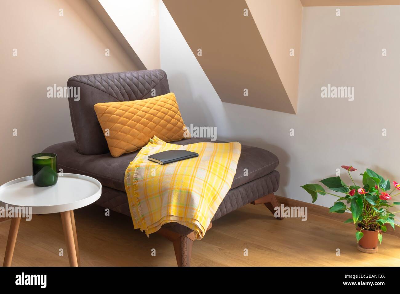 Komfortable, gemütliche Ecke zum Lesen. Stuhl mit Decke, Couchtisch und Blumentopf Stockfotografie