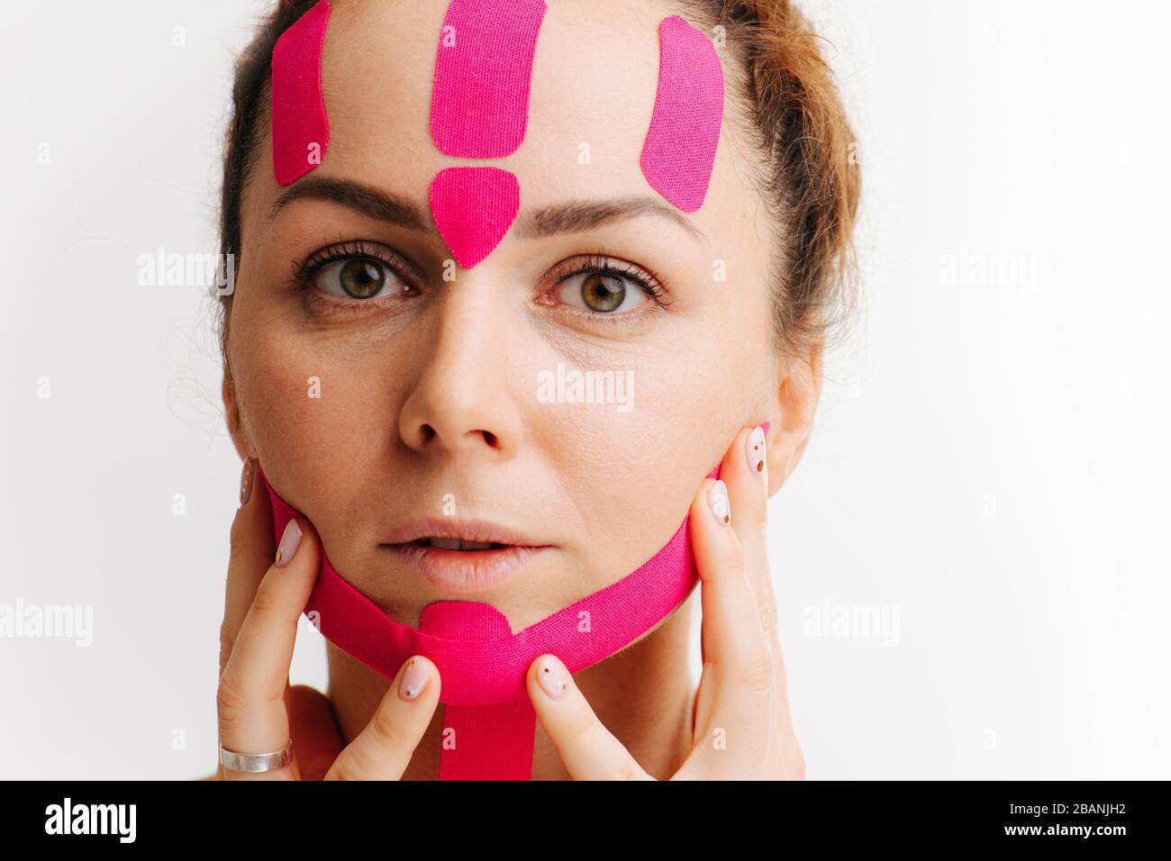 Nahaufnahme des Gesichts eines Mädchens mit kosmetologischem rosafarbenem Anti-Falten-Band Stockfoto