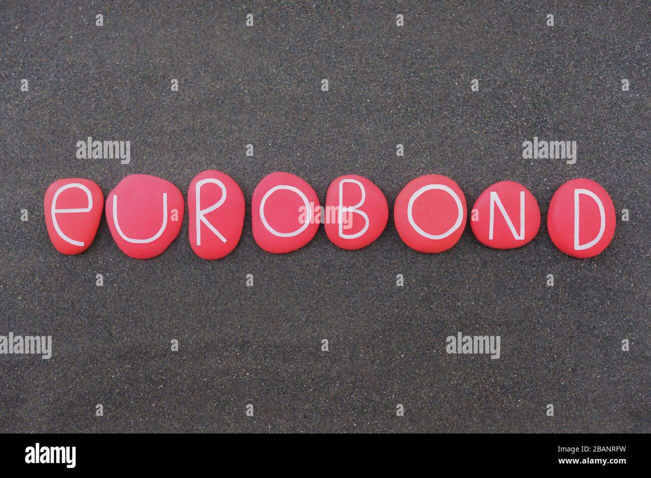 Eurobond-Wort mit rot gefärbten Steinbuchstaben über schwarzem Vulkansand Stockfoto