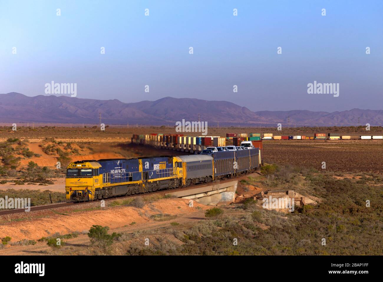 Güterzug transportiert doppelt gestapelte Module - Transportbehälter über die flache Landschaft in der Nähe von Port Auguata South Australia Stockfoto