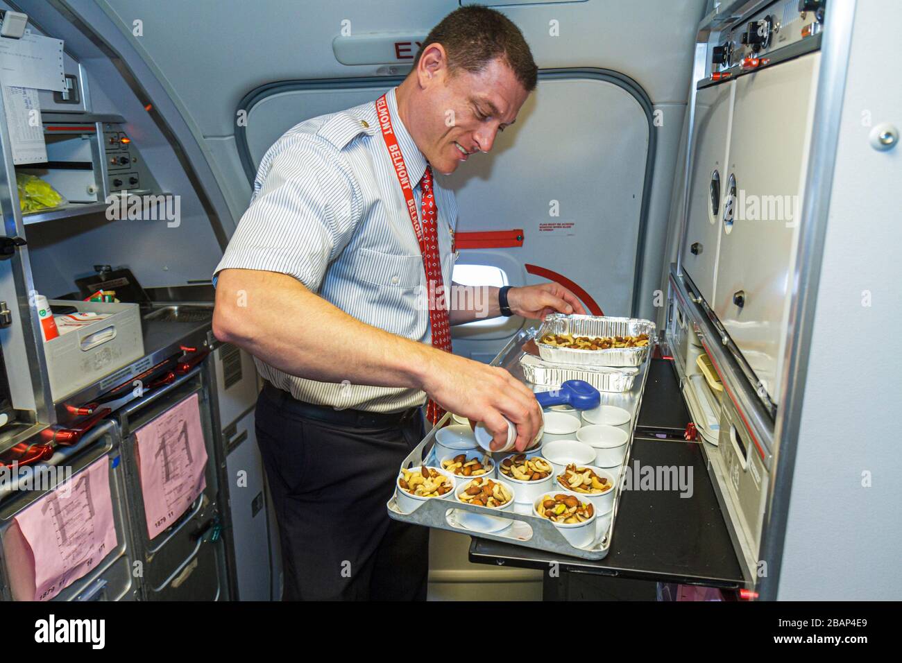 Miami Florida, Internationaler Flughafen, American Airlines, Flugbegleiter an Bord, der erstklassige Snacks zubereitete, männlicher Arbeiter Stockfoto
