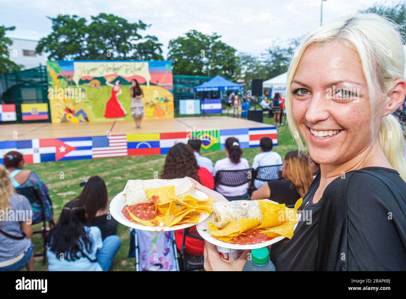 Miami Beach Florida, North Beach, Northshore Park, Hispanic Heritage Festival, Frau weibliche Frauen Erwachsene Essen, Tortilla, Burrito, Salsa-Sauce, lächelnd, h Stockfoto