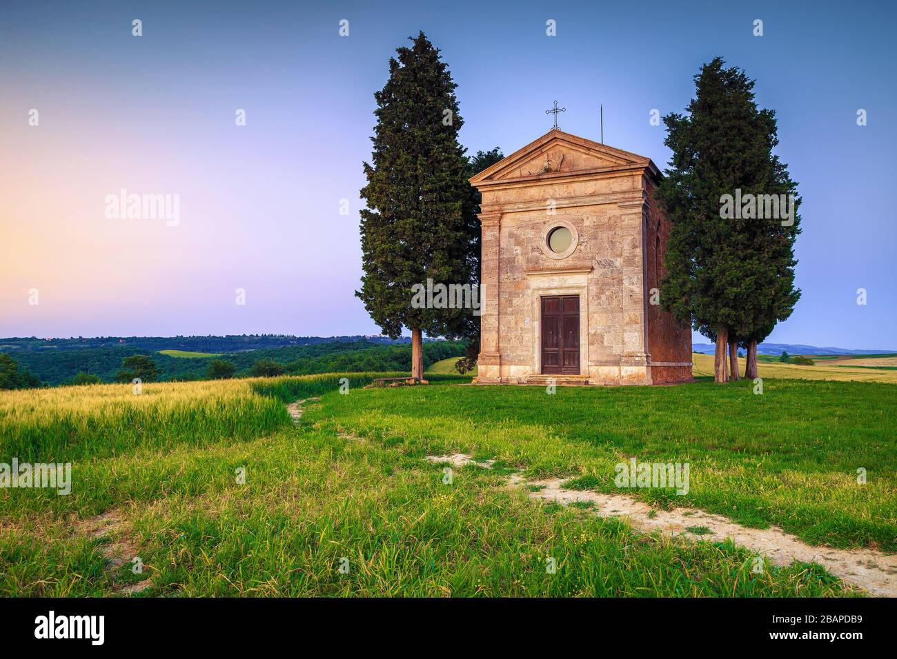 Niedliche kleine Vitaleta-Kapelle mit Getreidefeldern bei Sonnenuntergang, Pienza, Toskana, Europa Stockfoto