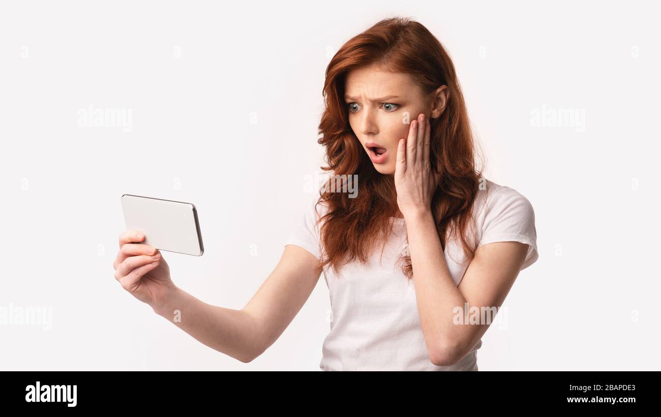 Mädchen, Die Smartphone Halten, Lesen Schockierende Nachrichten Online, Weißer Hintergrund Stockfoto