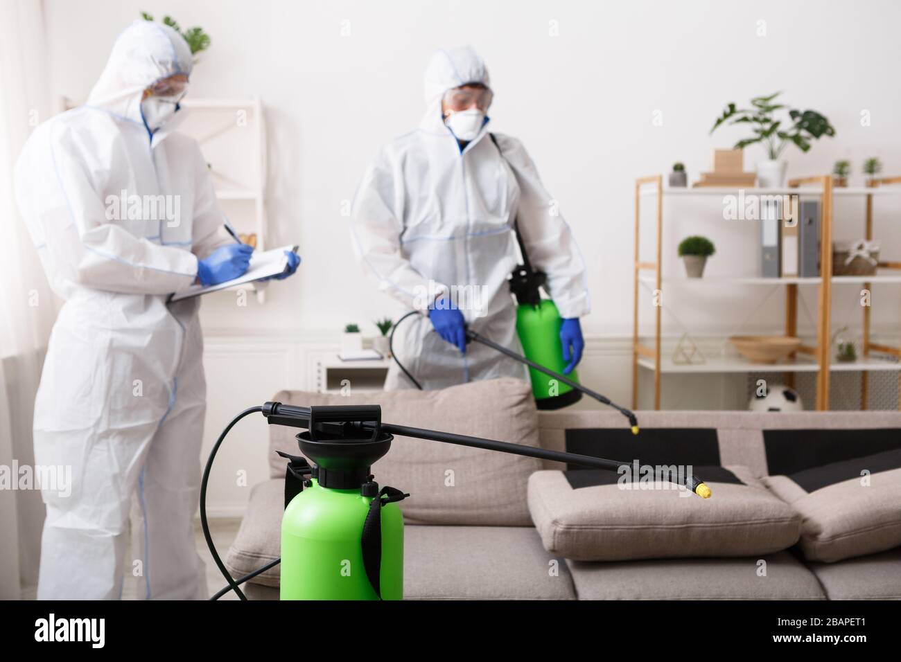 Männer in Hazmat sind für die Hausreinigung geeignet, Epidemie Stockfoto