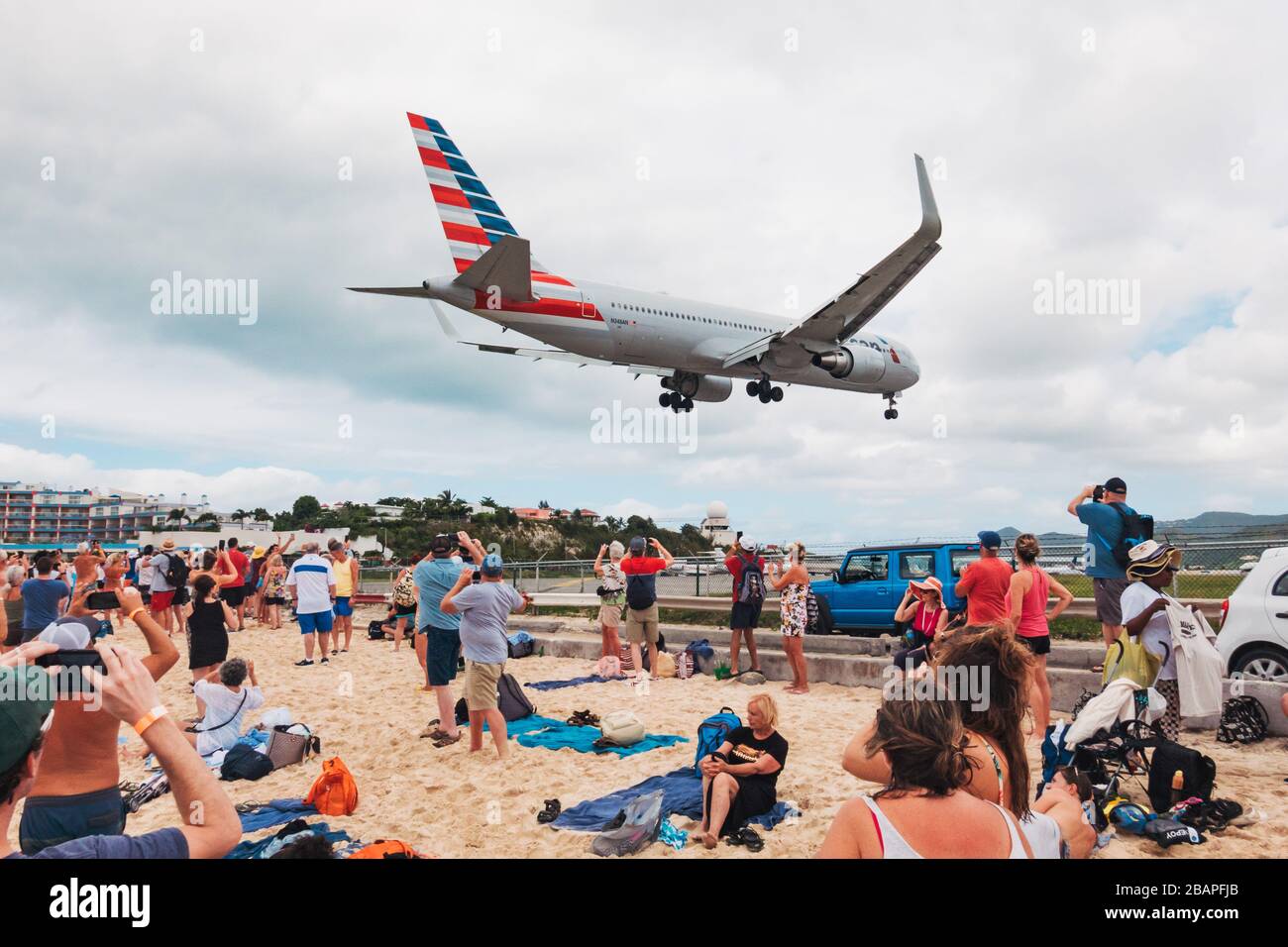 Eine Boeing 767-300er von American Airlines pfeift über einen Maho Beach, der mit Touristen von einem Kreuzfahrtschiff überfüllt ist, während sie bei Sint Maarten landet Stockfoto