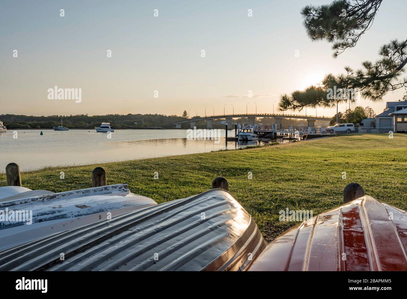 Die Morgensonne reflektiert auf Booten am Myall River, in der Nähe der Singing Bridge in der Stadt Tea Gardens, New South Wales, Australien Stockfoto