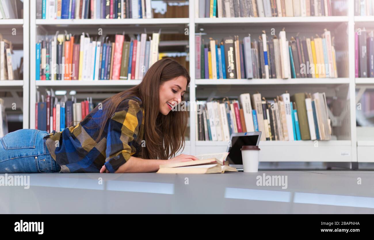 Junge Studentin, die in der Bibliothek studiert Stockfoto