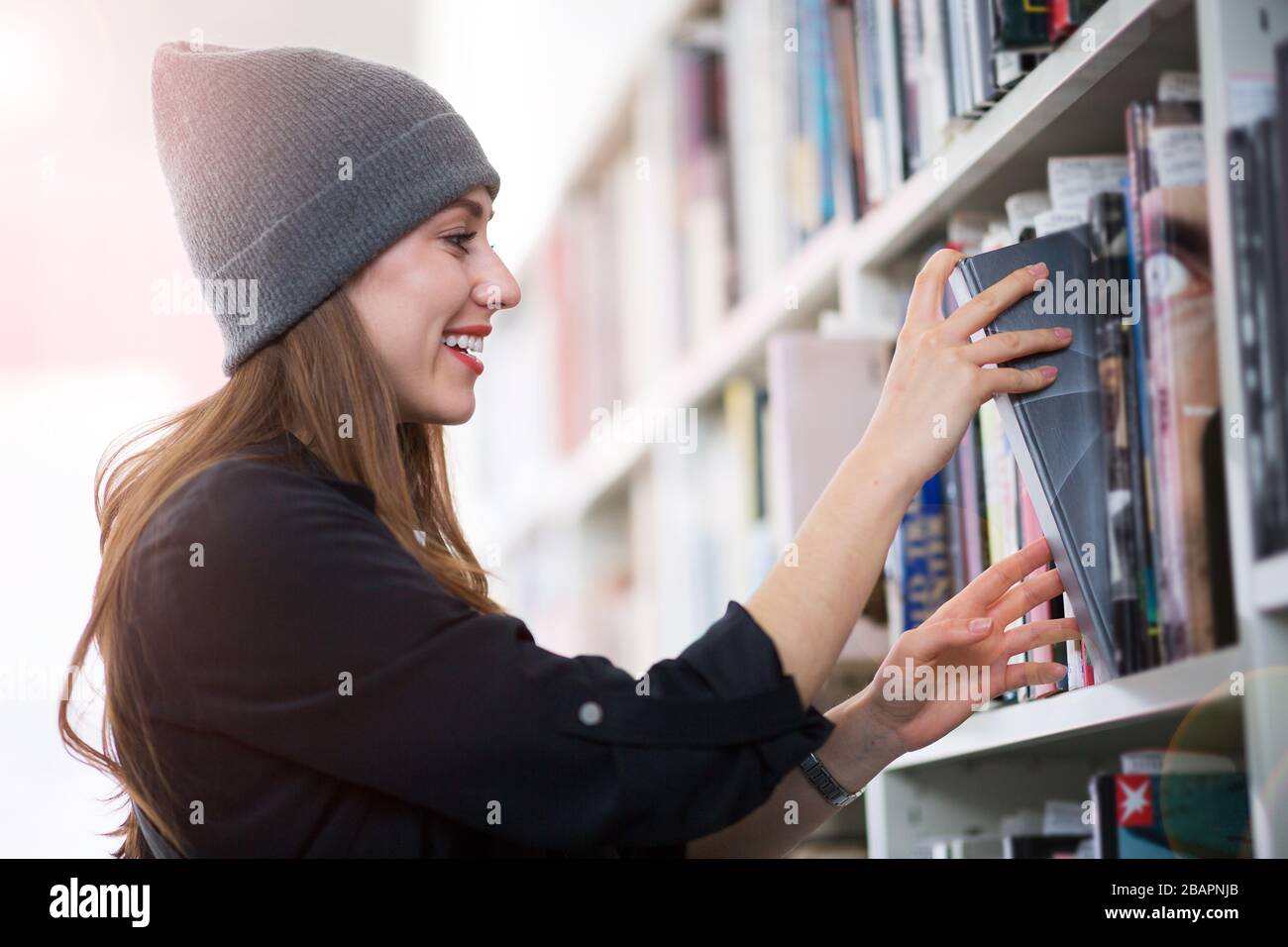 Junge Studentin, die in der Bibliothek studiert Stockfoto