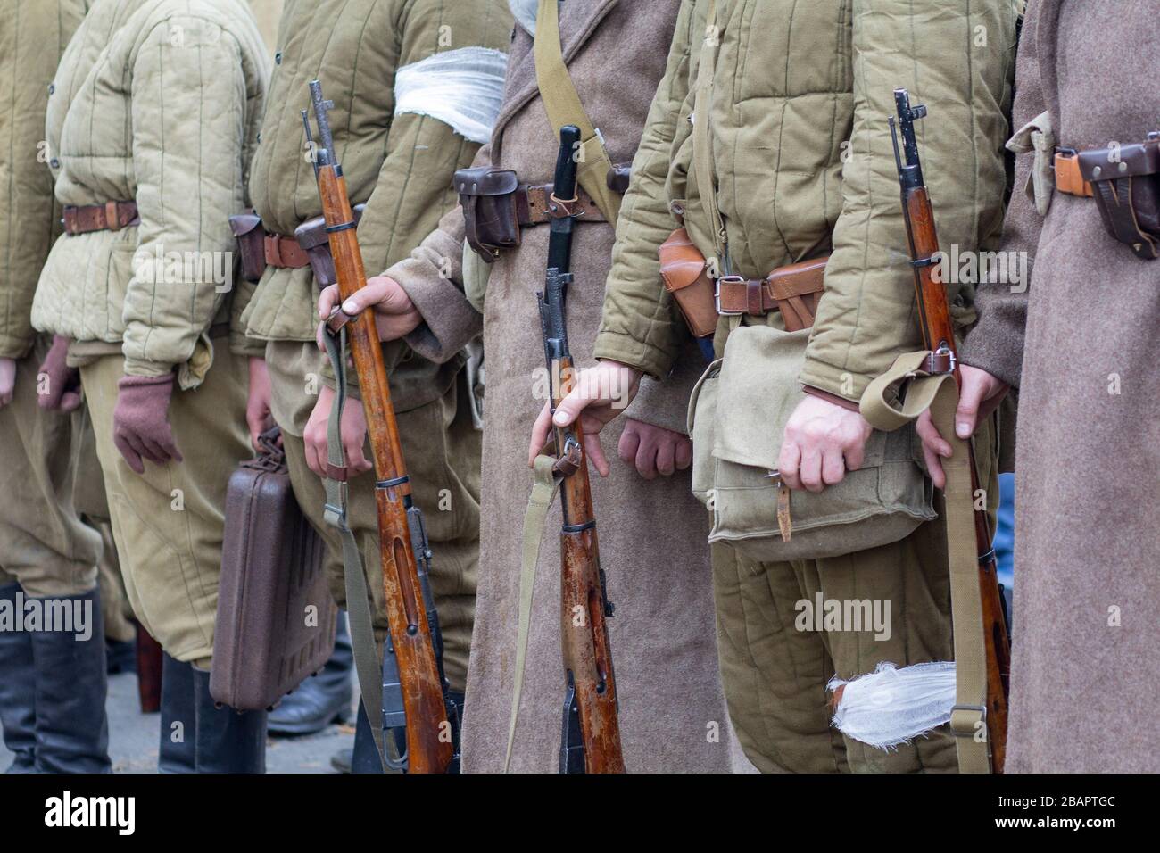 Umbenennende, die als Soldaten der sowjetischen Infanterie des zweiten Weltkriegs verkleidet sind, halten Gewehrwaffen in Händen Stockfoto