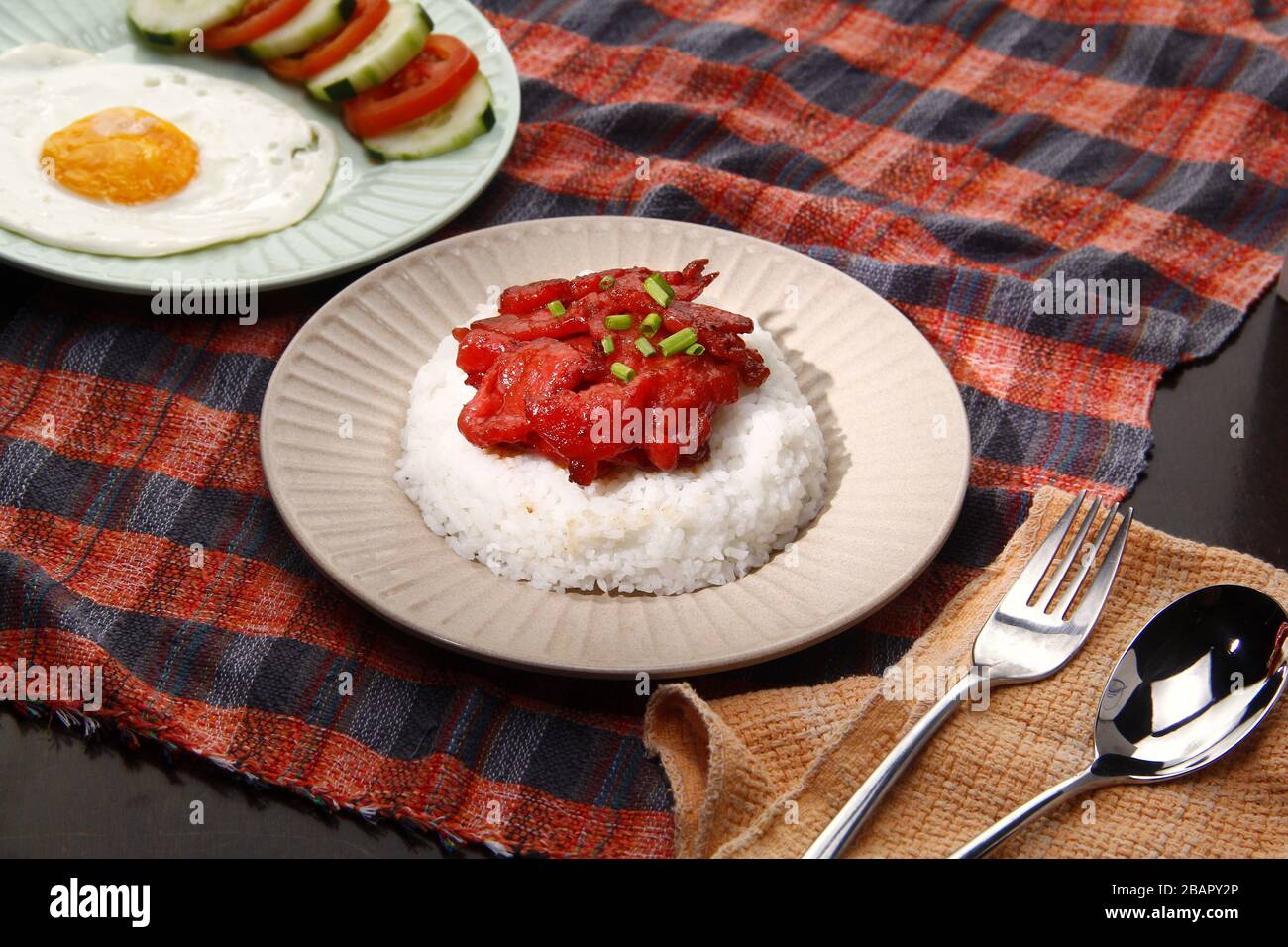 Foto von frisch gekochtem Tocino oder gehärtetem Schweinefleisch, serviert mit gebratenem Reis und Ei mit Gemüse. Stockfoto