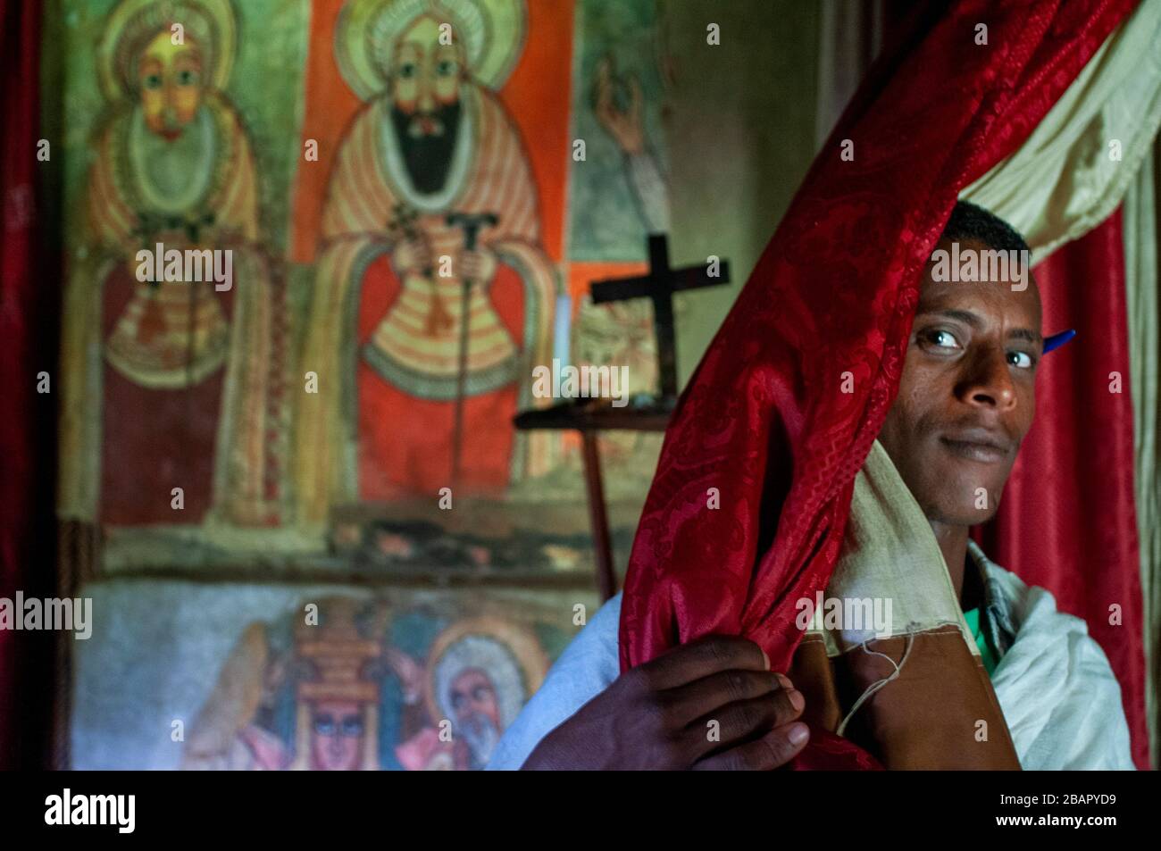 Debre Sina Beta Maryam Kirche, Lake Tana, Bahir dar, Äthiopien. Ein Priester posiert majestätisch mit seinem Kreuz an der Tür des Klosters Birgida Maryam auf o Stockfoto