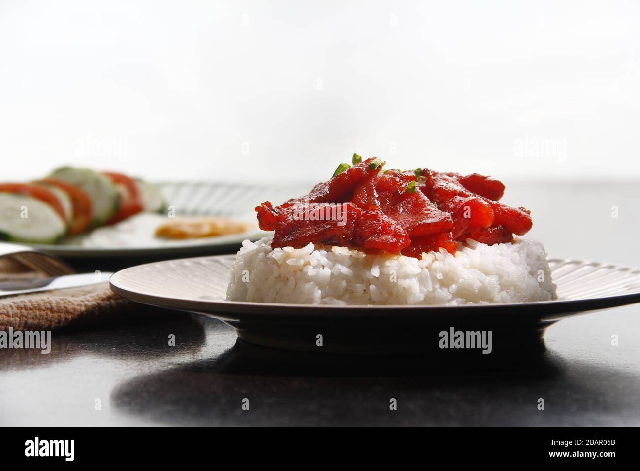 Foto von frisch gekochtem Tocino oder gehärtetem Schweinefleisch, serviert mit gebratenem Reis und Ei mit Gemüse. Stockfoto