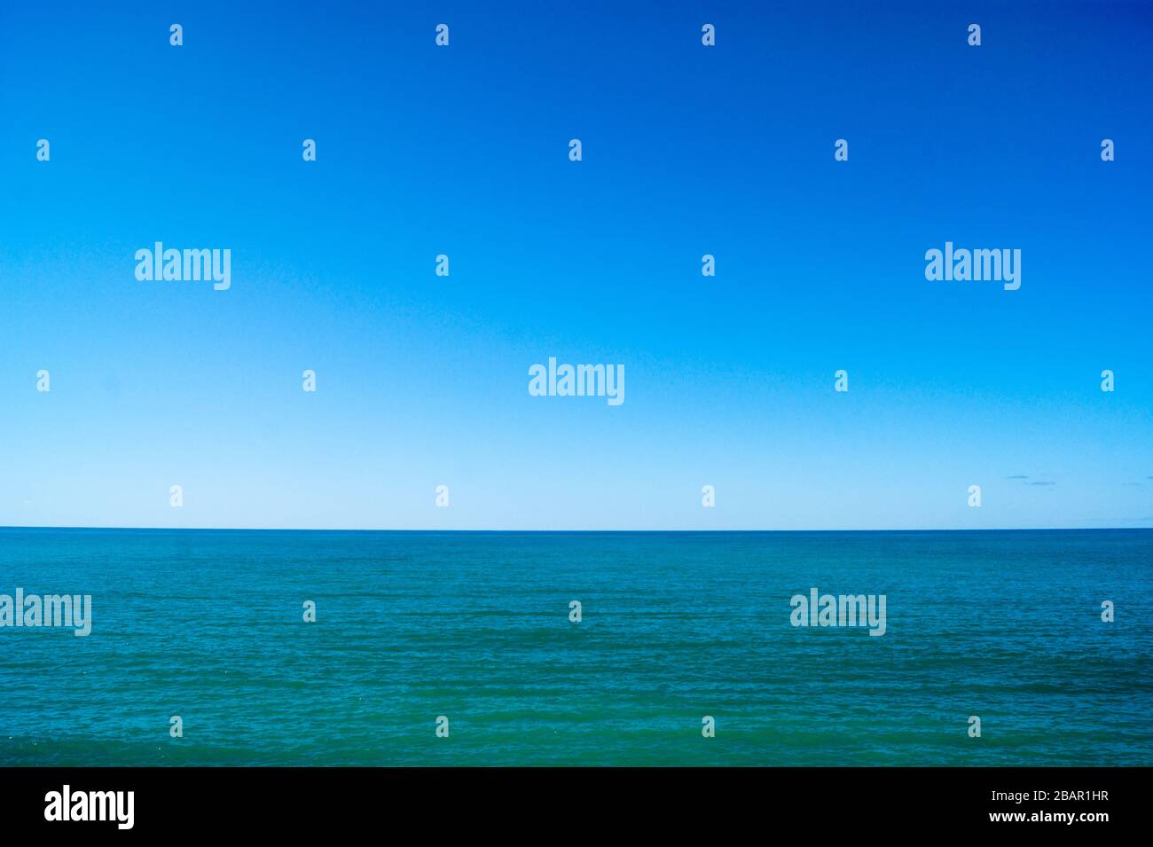 Ruhiges Meer und blauer Himmel, horizontales Foto. Die Horizont-Linie teilt das Foto in die Hälfte Stockfoto