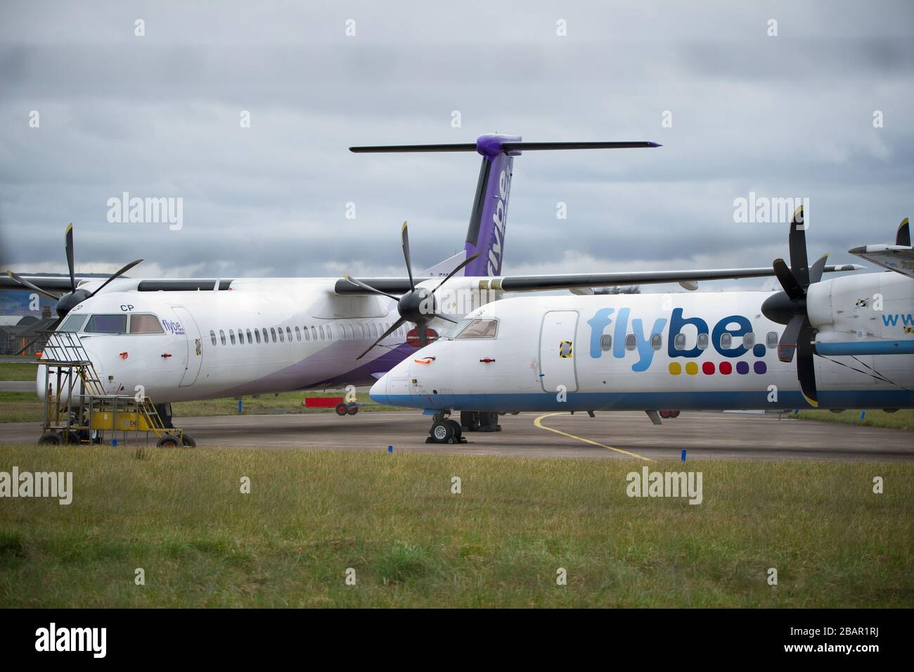 Glasgow, Großbritannien. März 2020. Abbildung: Geerdete Flugzeuge vom Typ Flybe de Havilland Canada Dash 8 Q400, die am Emergency Rendezvous Point am Flughafen Glasgow auf dem Asphalt geparkt waren. Die Pandemie von Coronavirus war für die britische Flugbahn verantwortlich, die den Flughafen Glasgow dazu brachte, eher wie eine Geisterstadt zu aussehen. Kredit: Colin Fisher/Alamy Live News. Stockfoto