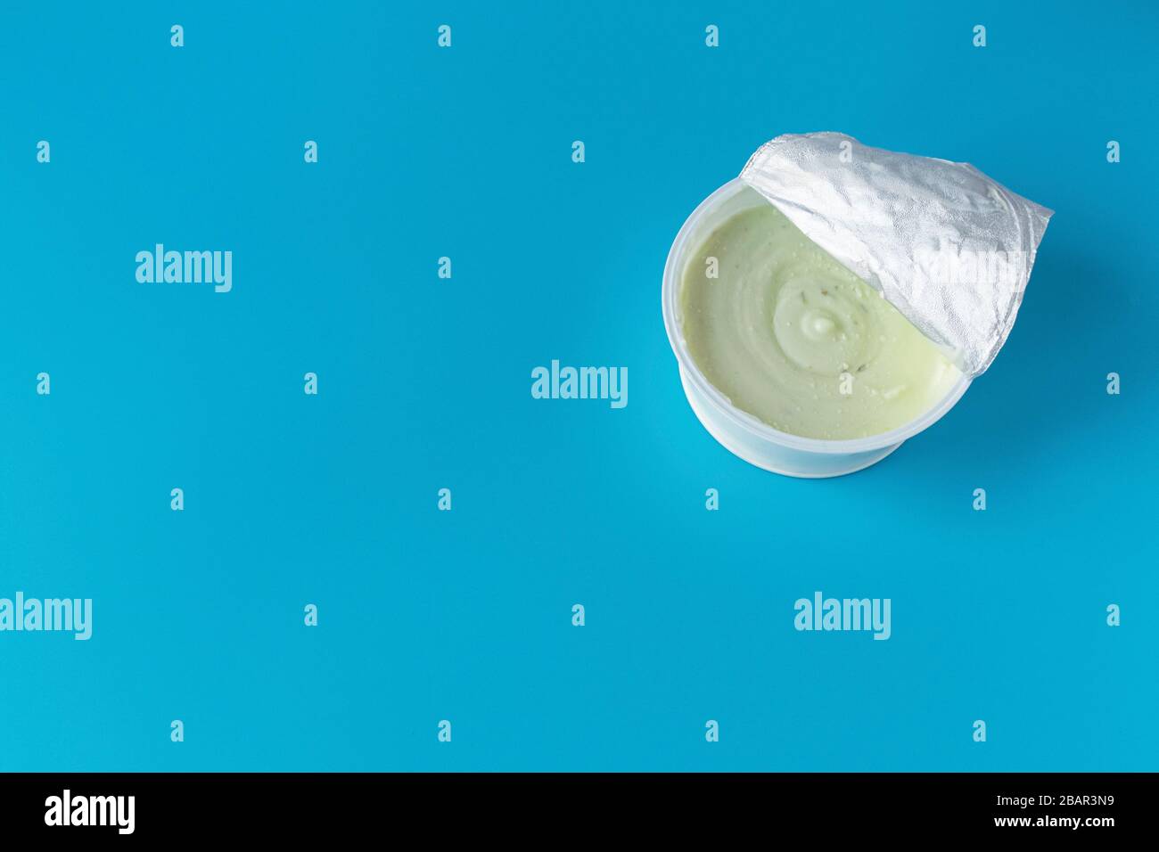 Joghurt in einem Glas auf blauem Hintergrund. Ein gesundes leichtes Diät-Frühstück. Milchprodukte. Stockfoto