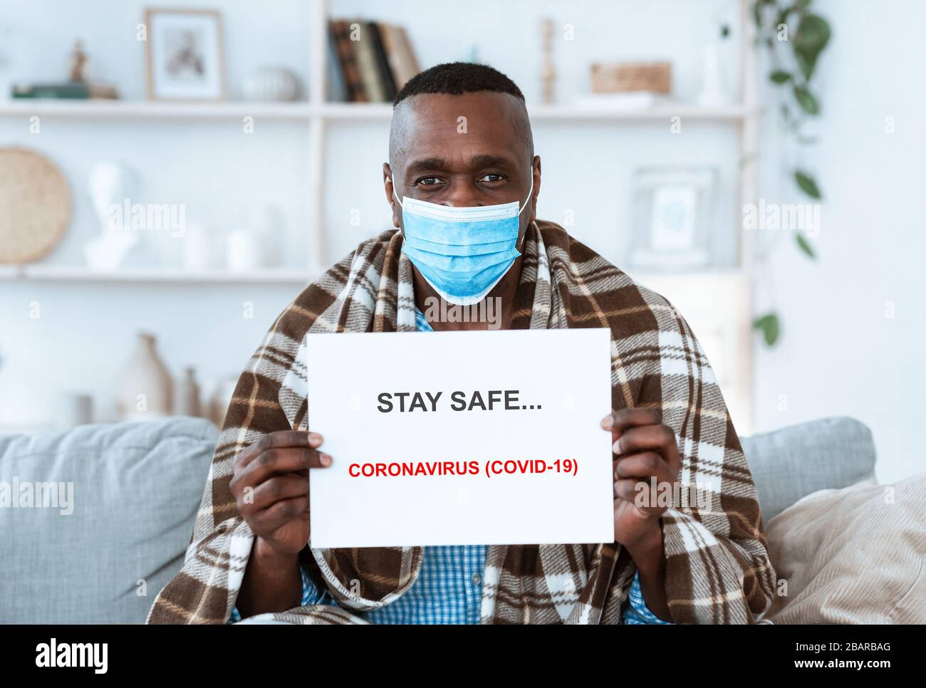 Bleiben Sie bei einem Virusausbruch sicher. Ein erfahrener afroamerikanischer Mann hält Papier mit Anti-Coronavirus-Text in Innenräumen Stockfoto