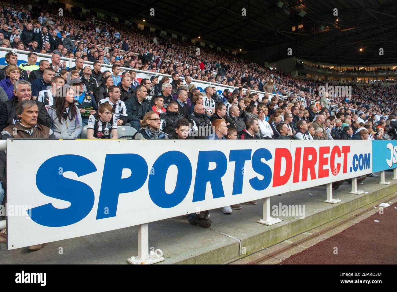 Fans sehen sich das Spiel hinter sportsdirect.com Signage an Stockfoto