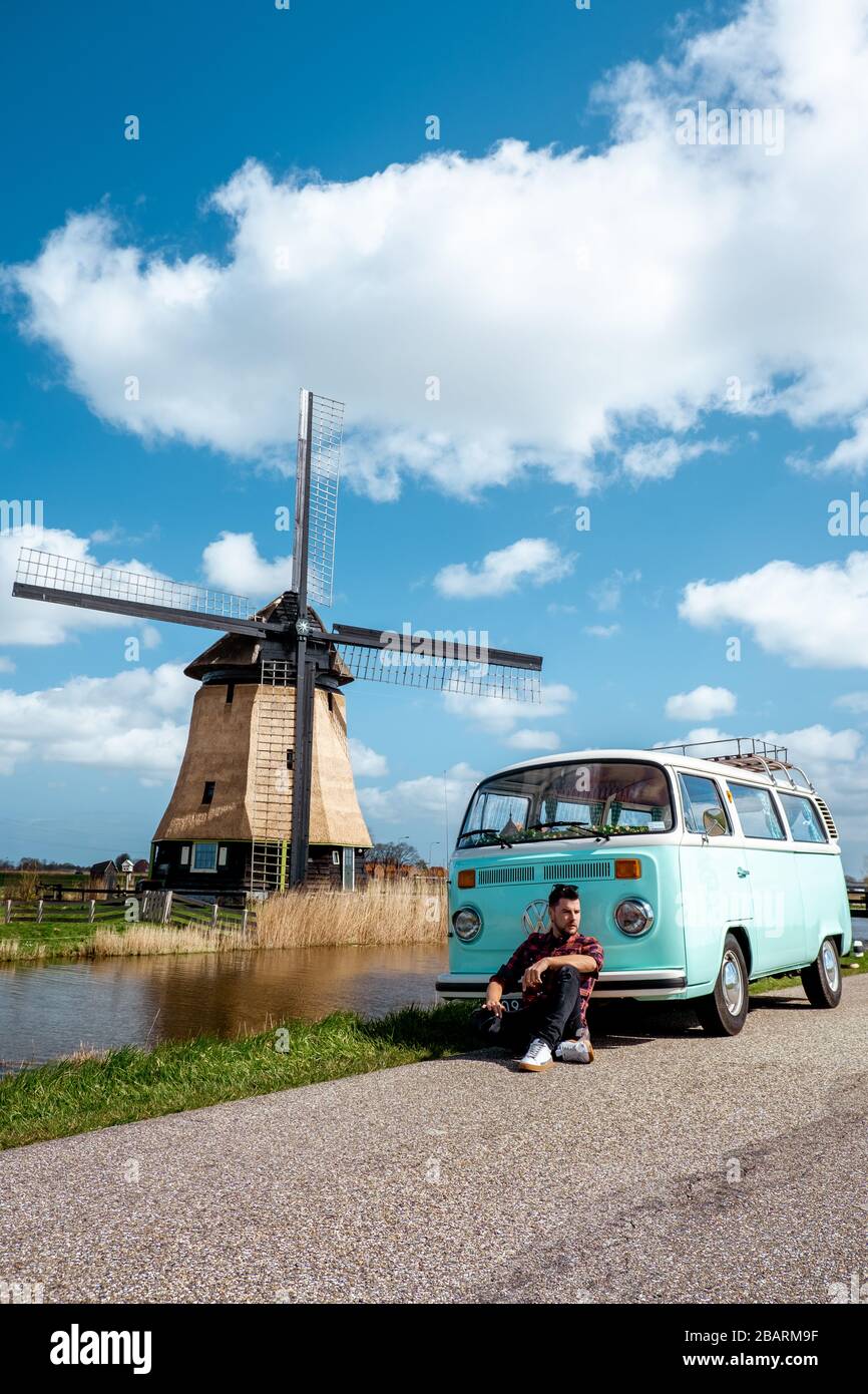 Der alte Oldtimer, der von der historischen Windmühle in Holland
